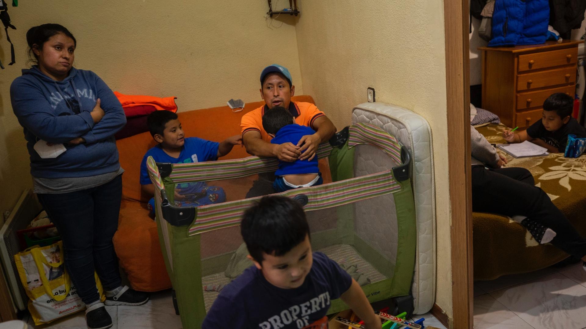 Erika Oliva, left, and her husband Benjamin Lopez's family gather inside their apartment in the southern neighborhood of Vallecas, in Madrid, Spain, Oct. 15, 2020. 