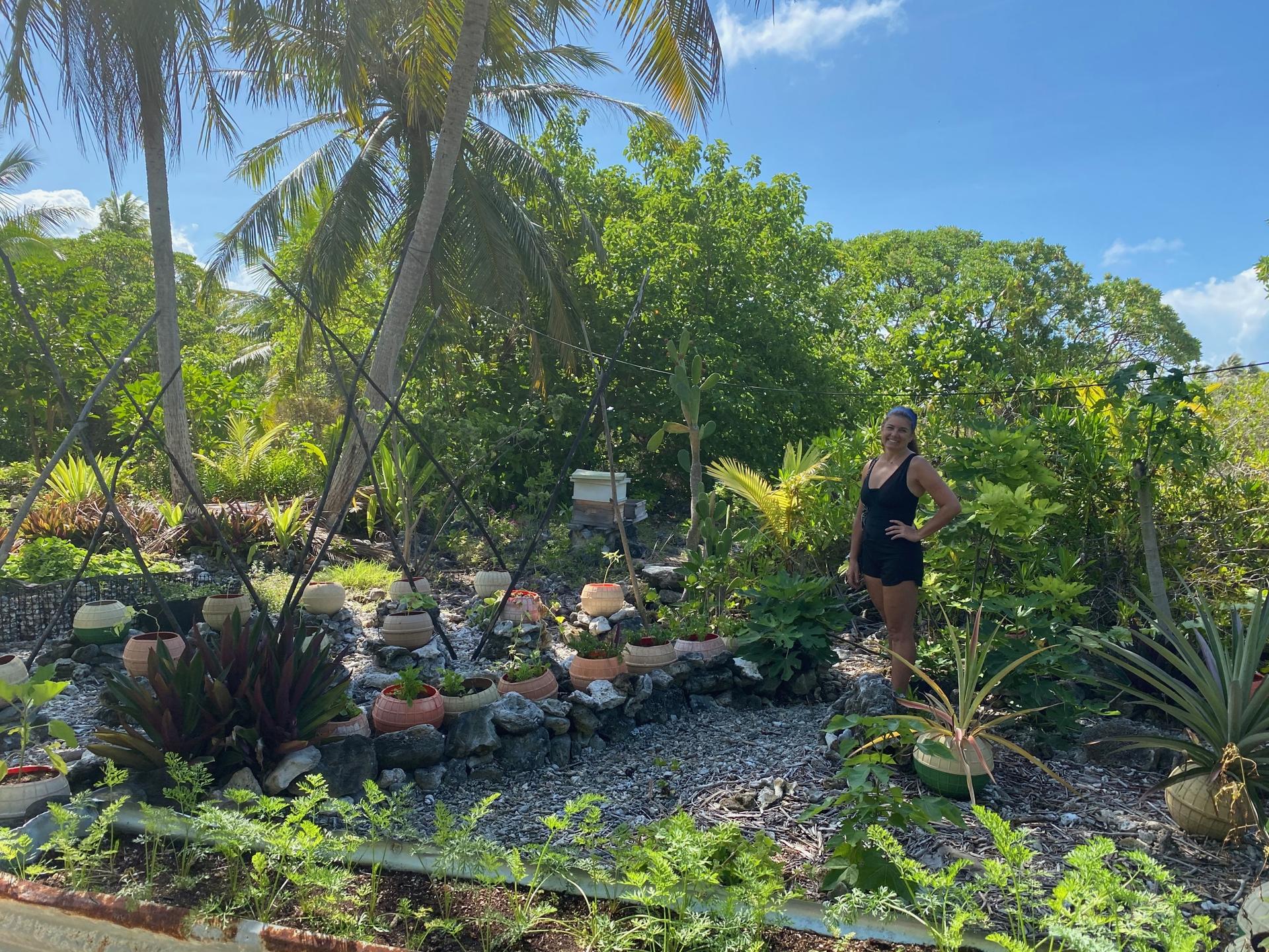 Kamoka Pearl co-owner Celeste Brash stands in front of a portion of the large garden that helps feed the farm crew. In soil made from bird droppings and coconut husks, they're attempting to grow everything from arugula and pineapples to taro and carrots i