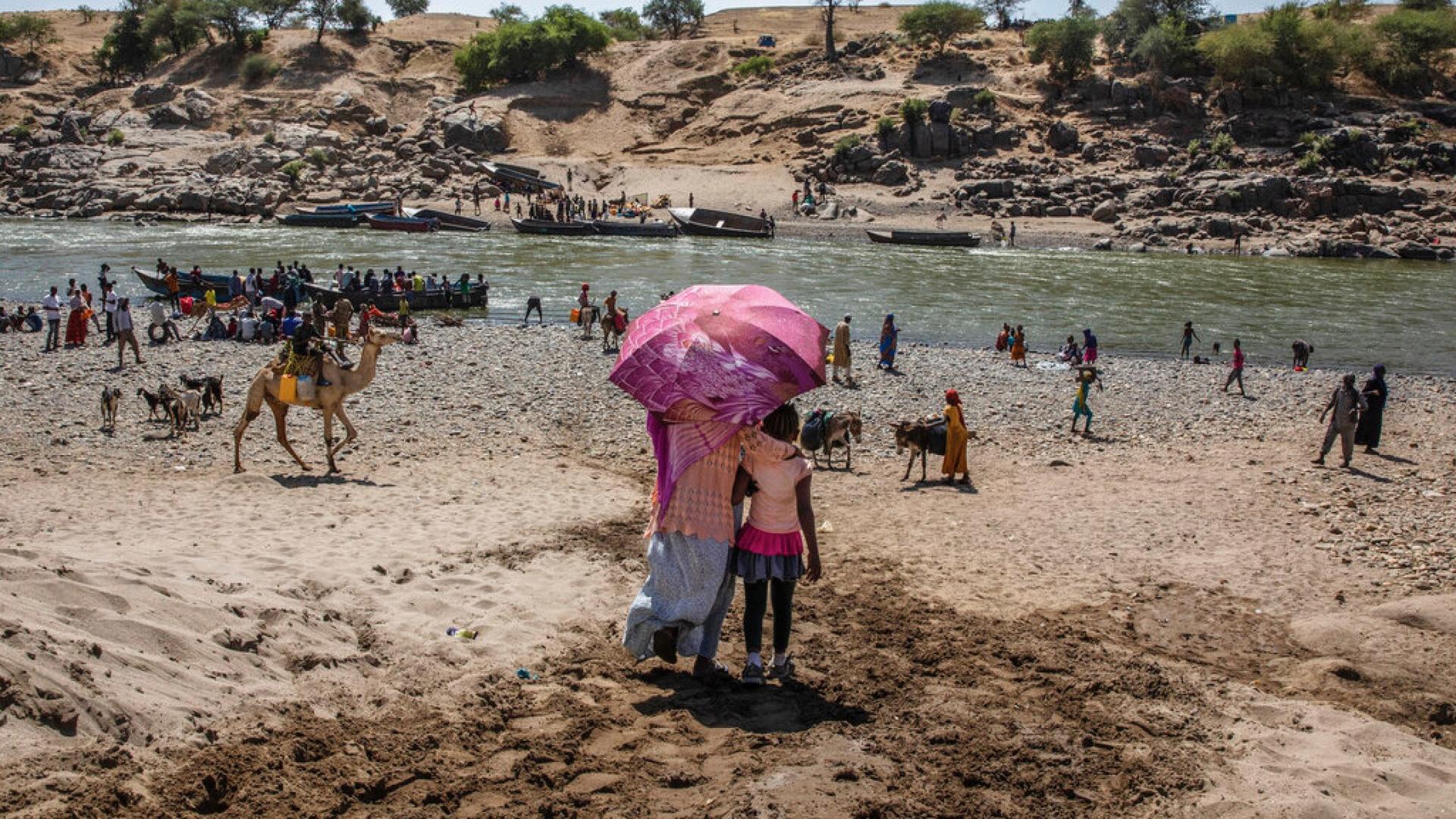 Refugees who fled the conflict in Ethiopia's Tigray region arrive on the banks of the Tekeze River on the Sudan-Ethiopia border, in Hamdayet, eastern Sudan, Nov. 21, 2020. Huge unknowns persist in the deadly conflict, but details of the involvement of nei