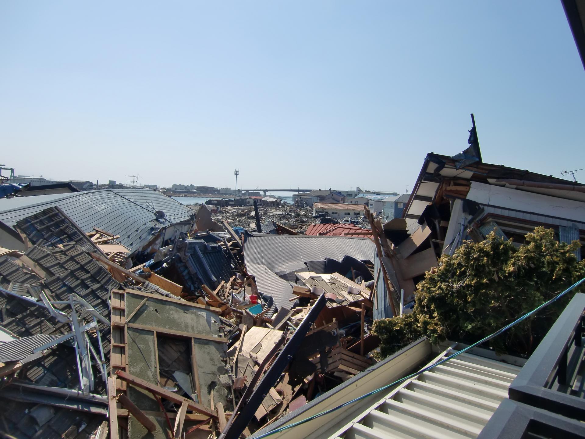 Houses are shown destroyed and collapsed on each other.
