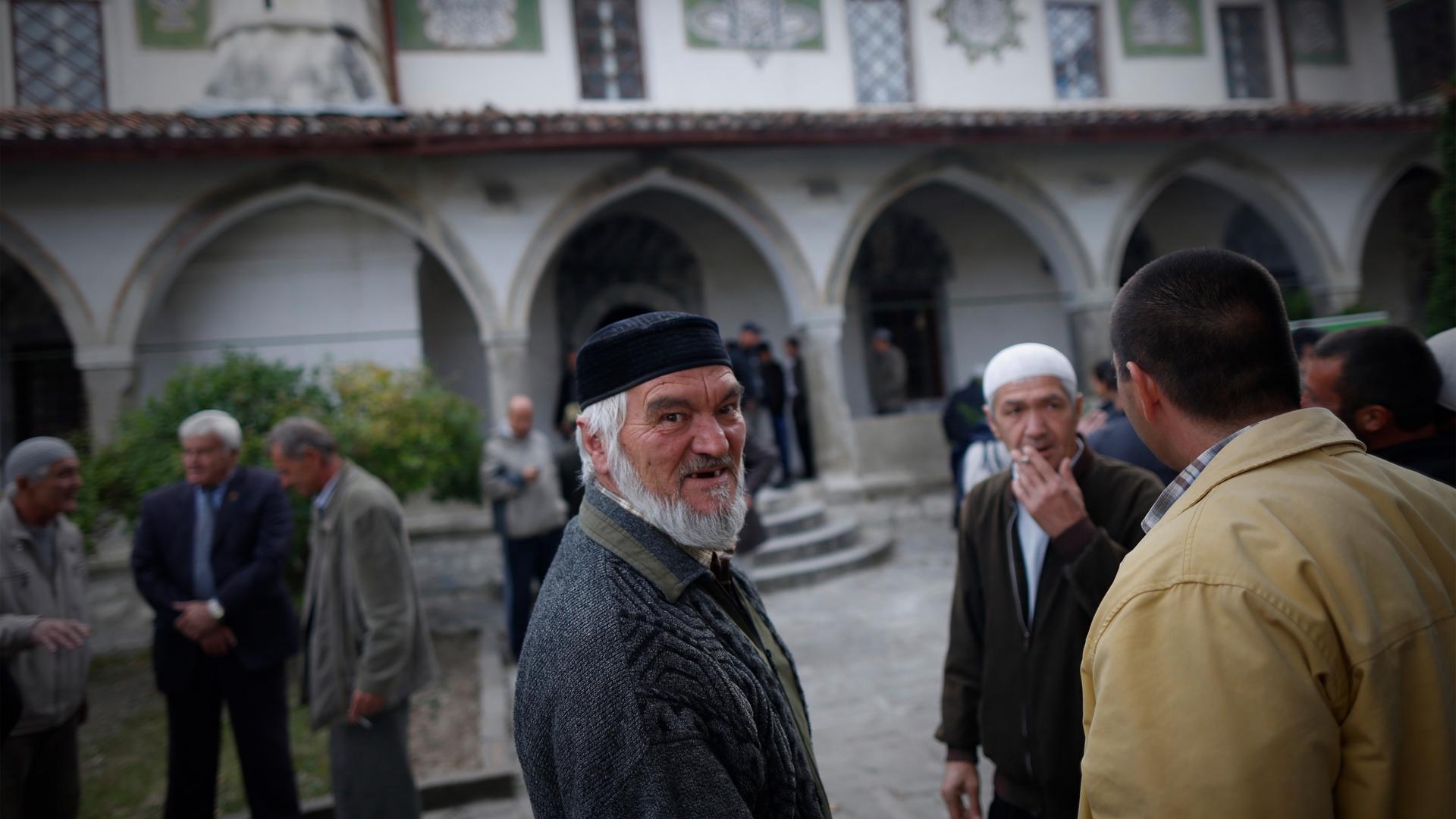 Crimean Tatars speak after the prayer in a Mosque marking the Eid al-Adha, celebrated by Muslims worldwide, in Bakhchisarai, Crimea, on Sat. Oct. 4, 2014.