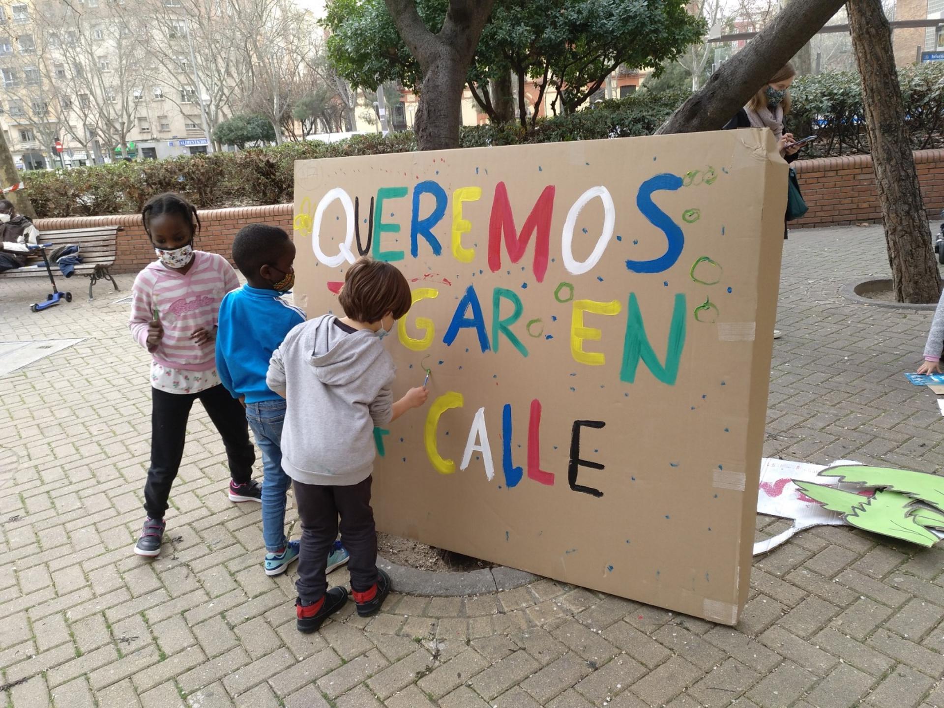 Children gather around an anti-car sign