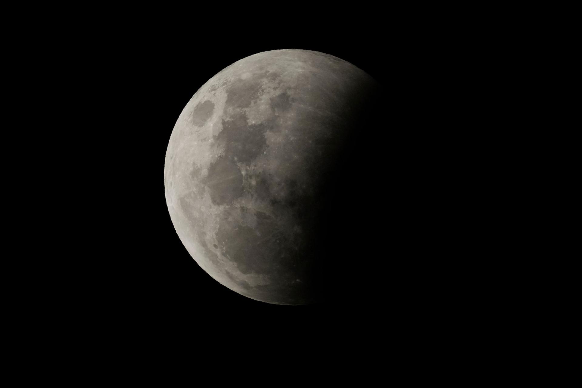 The beginning of a total lunar eclipse with a shadow on about 25% of the moon.