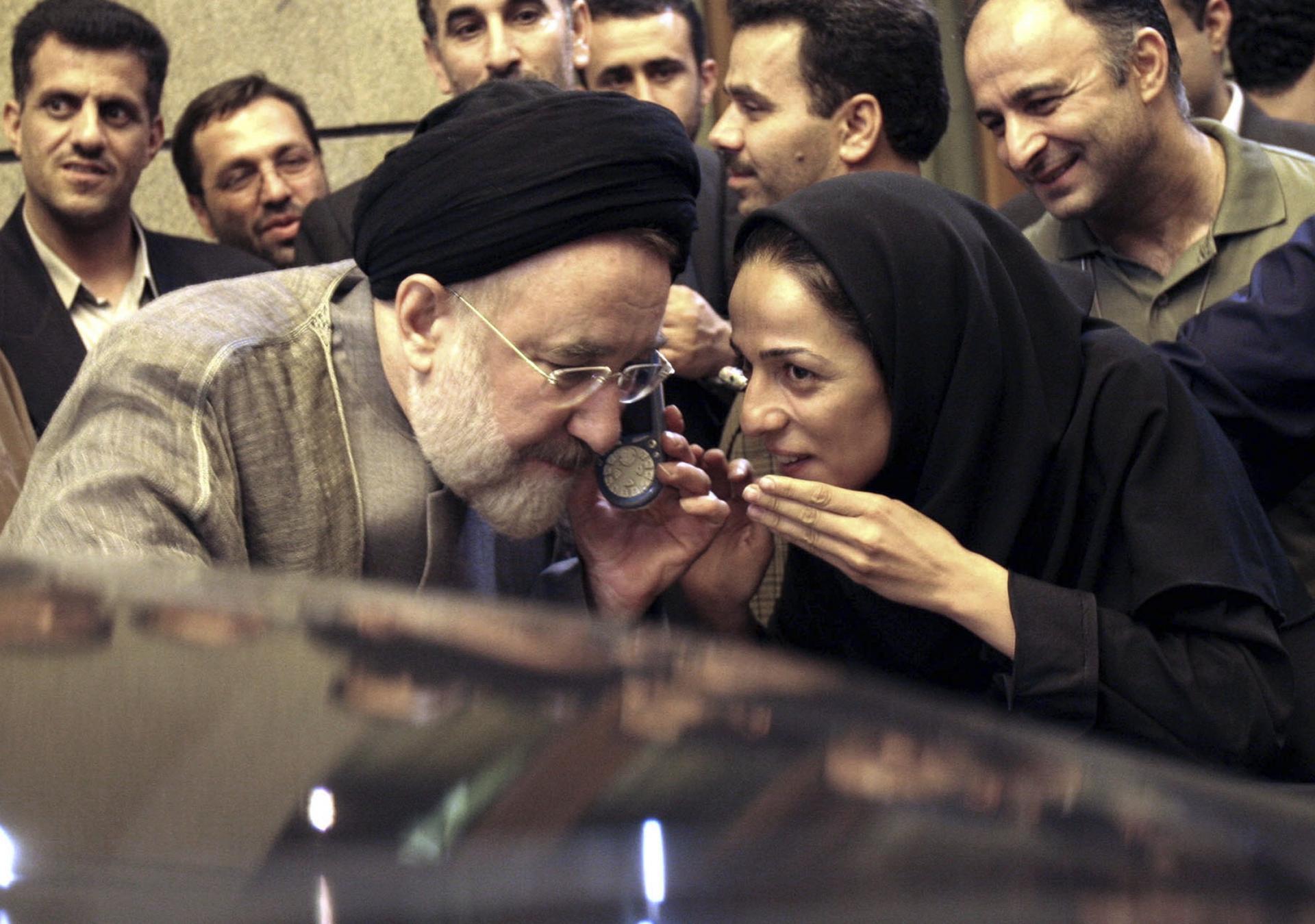 Outgoing reformist Iranian President Mohammad Khatami talks on the phone with the mother of female journalist Masih Alinejad, right, after meeting with journalists in Tehran, Iran, July 13, 2005.