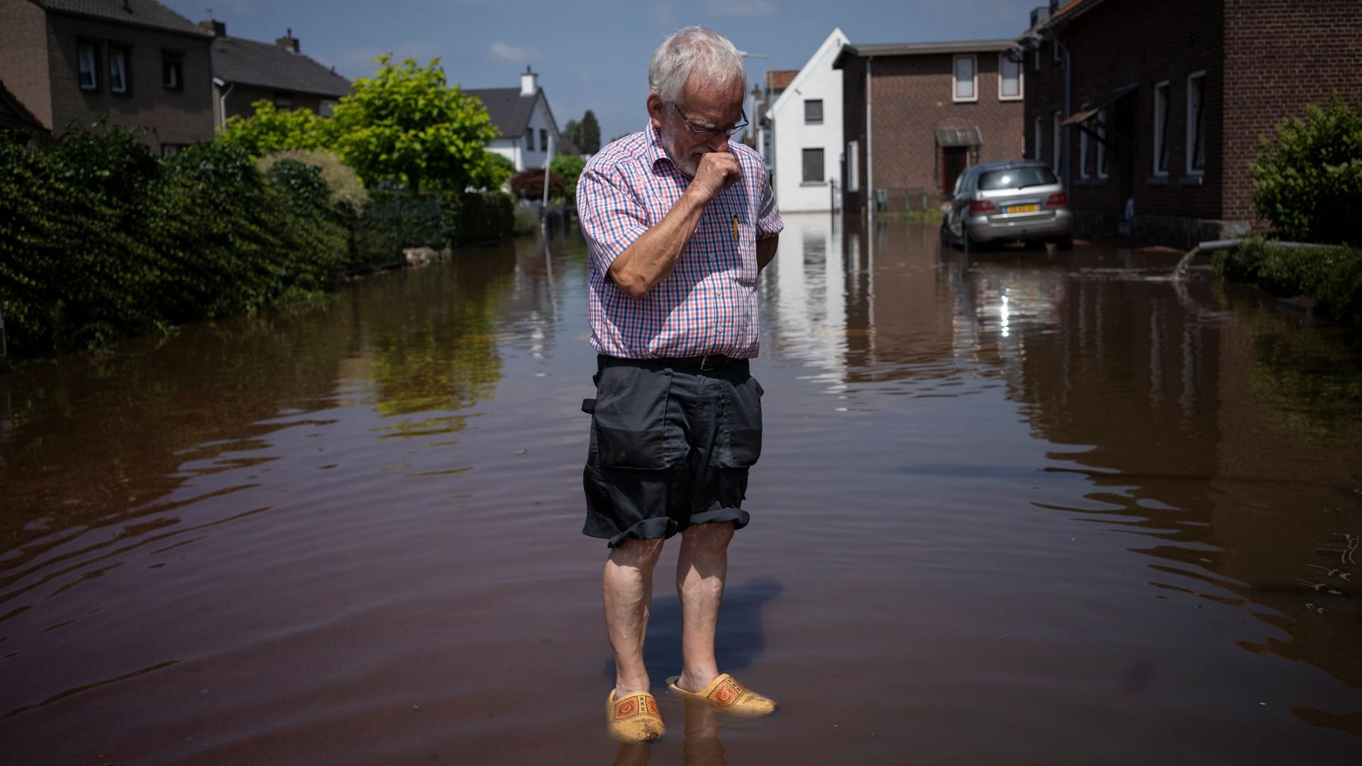 Wiel de Bie, 75, stands outside his flooded home in the town of Brommelen, Netherlands, July 17, 2021. 