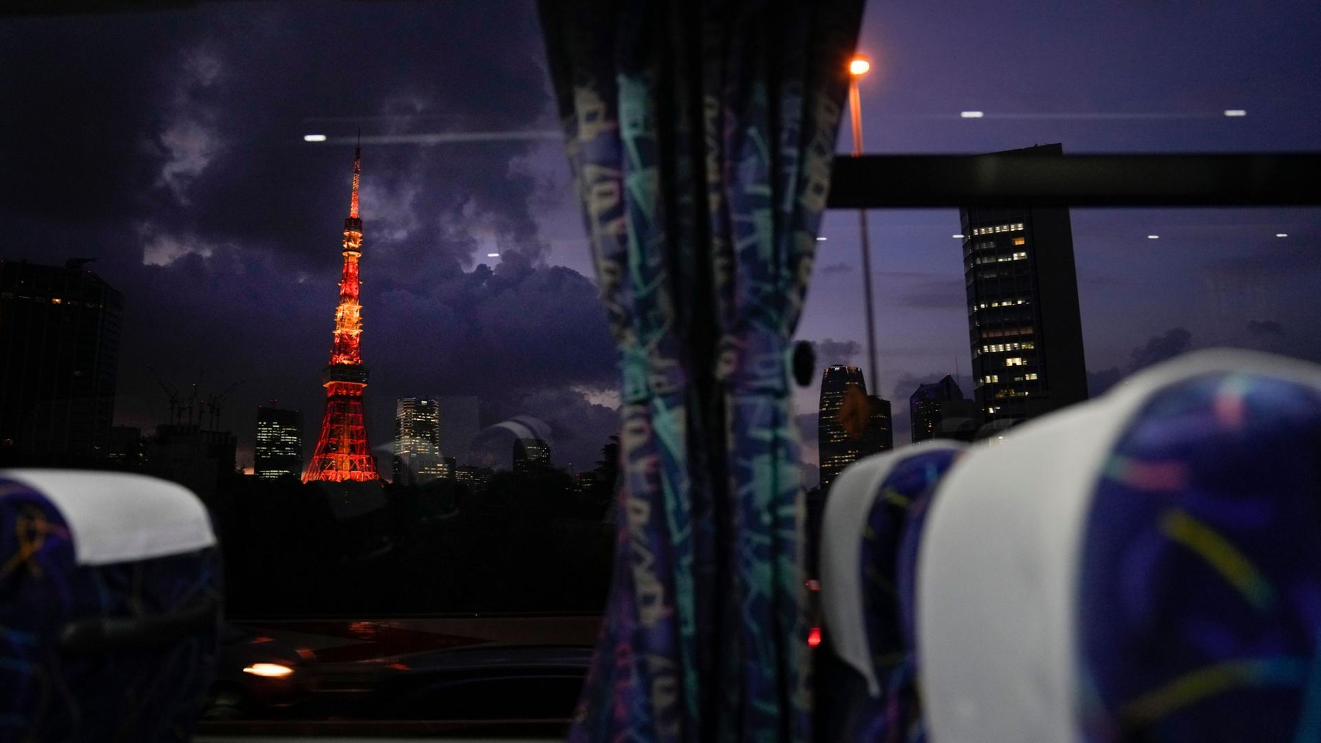 The Tokyo Tower is shown in the distance illuminated with red and orange lighting.