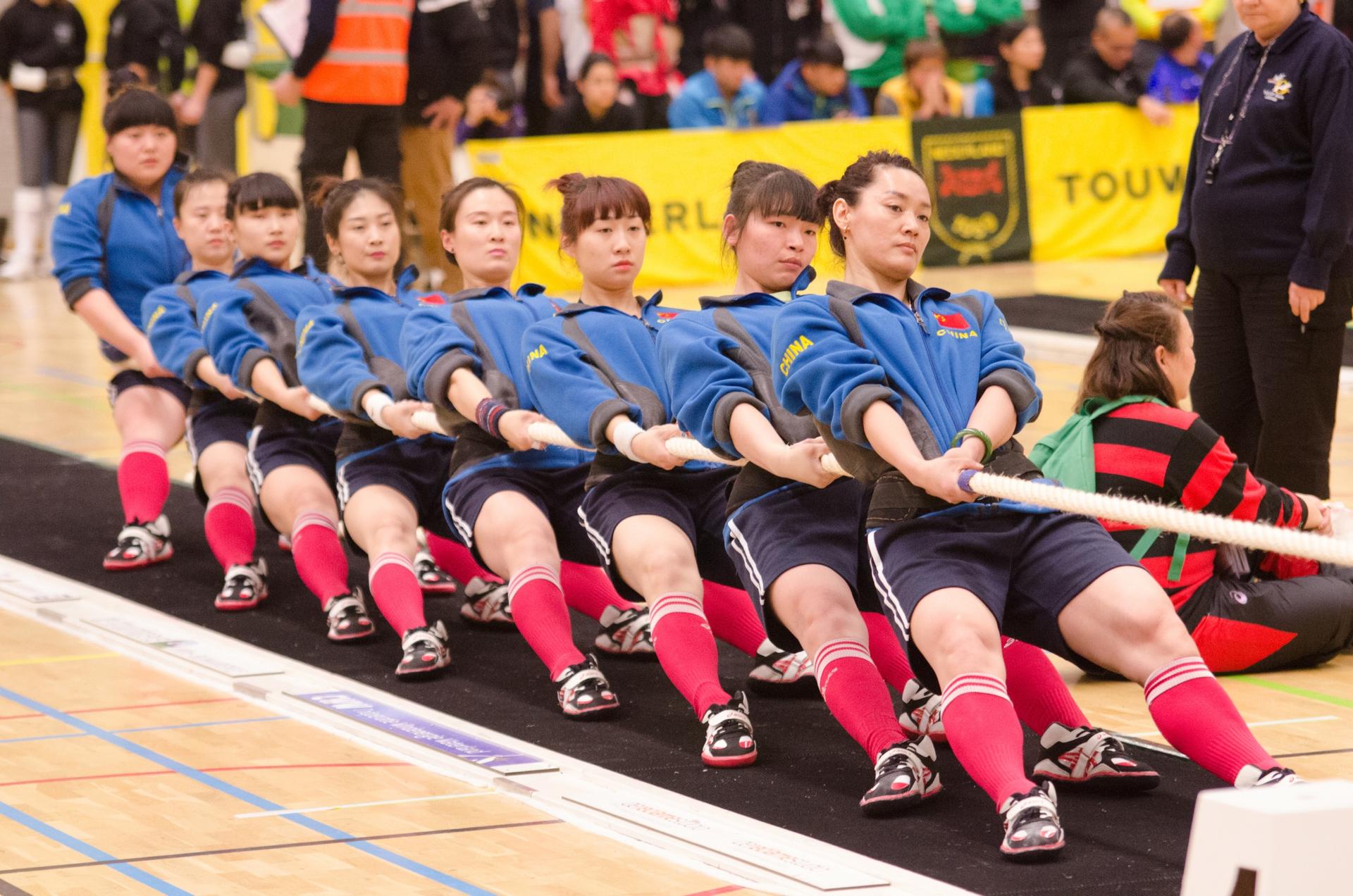 A team of women from China compete in a tug of war competition. 
