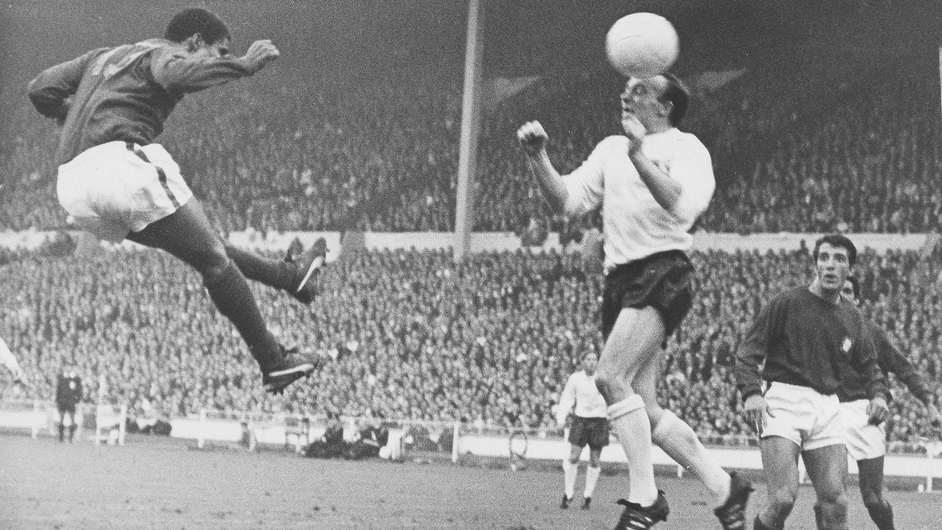 Portugal's Eusebio, left, and England's Nobby Stiles have a heading duel for the ball during their World Cup semi-final match at Wembley, London, July 26, 1966. 