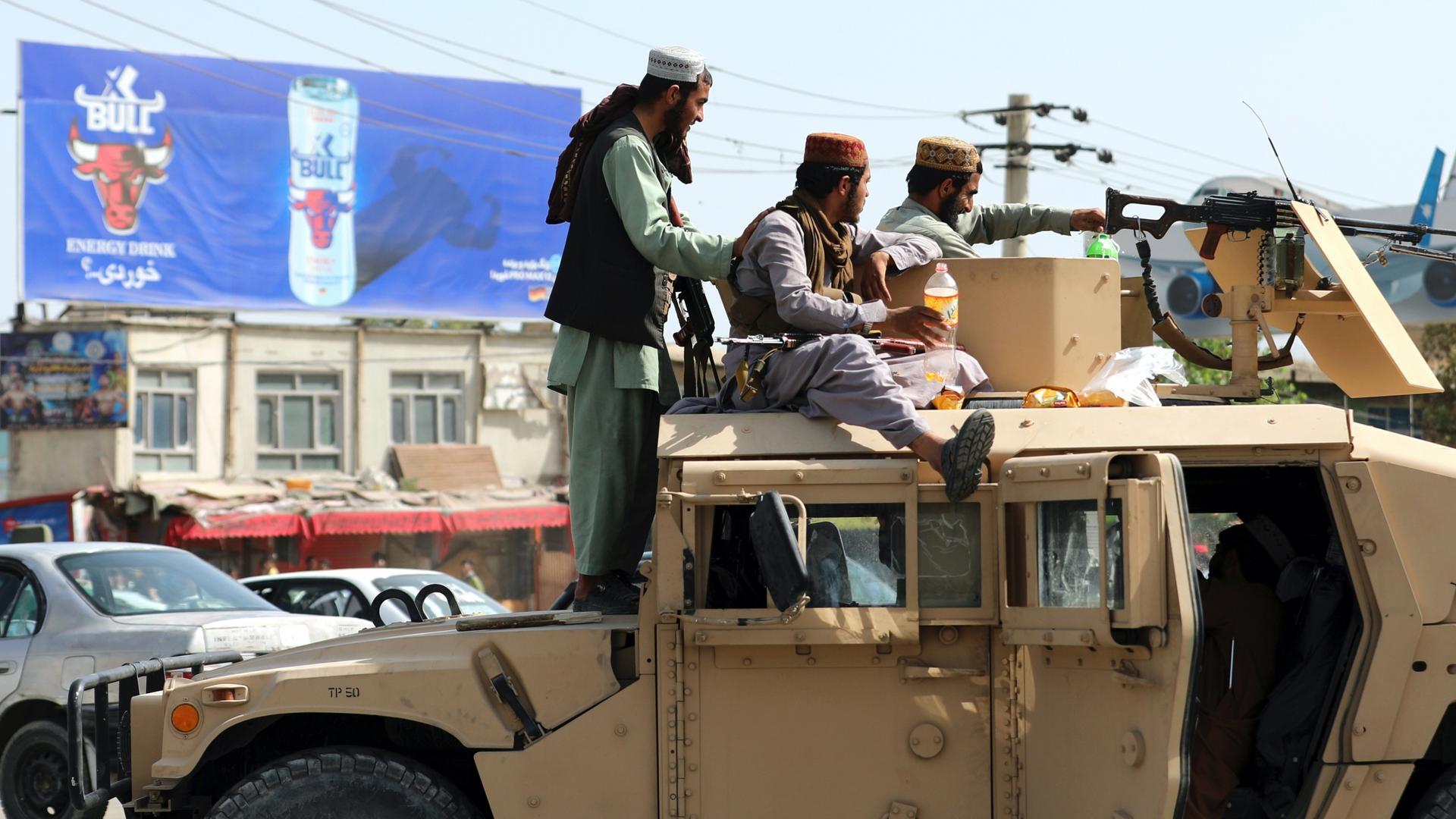 Taliban fighters stand guard in front of the Hamid Karzai International Airport, in Kabul, Afghanistan, Aug. 16, 2021.
