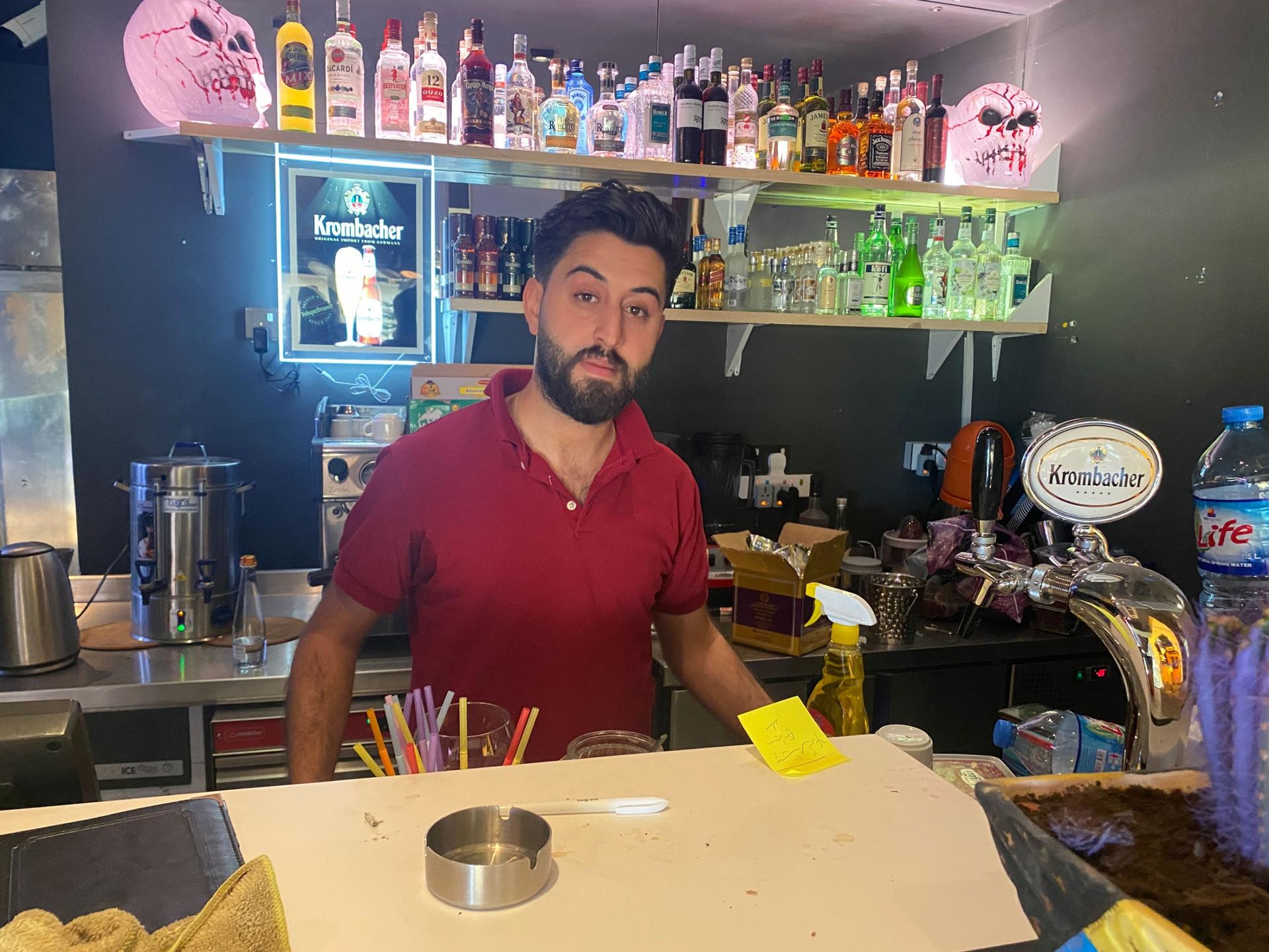 Mabast Zaman is a waiter wearing a red shirt behind a bar at Senorita TexMex restaurant, Erbil, Iraq. 