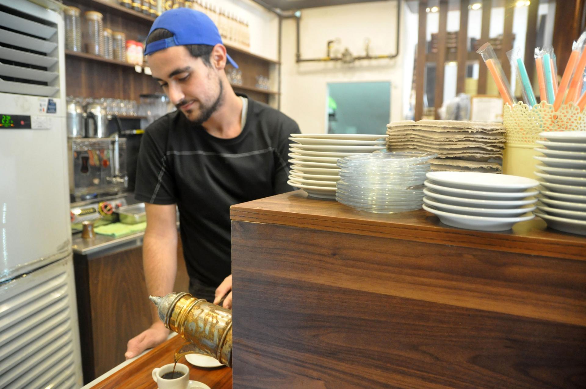 A worker pours a cup of strong coffee at a Syrian sweet shop in Istanbul. Unemployment rates in Turkey are high, and the pandemic affected Syrian workers particularly severely. 