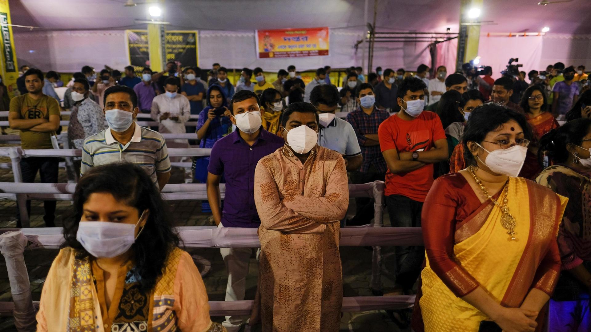 People wearing masks as a precautionary measure against the coronavirus assemble to offer prayers at Dhakeshwari Temple during a Hindu Durga Puja festival in Dhaka, Bangladesh