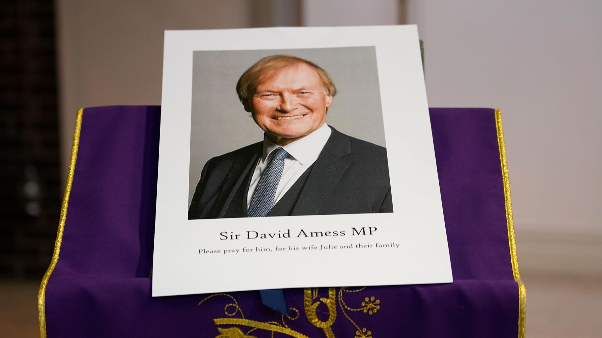 An image of murdered British Conservative lawmaker David Amess is displayed near the altar in St. Peters Catholic Church before a vigil in Leigh-on-Sea, Essex, England, Friday, Oct. 15, 2021.