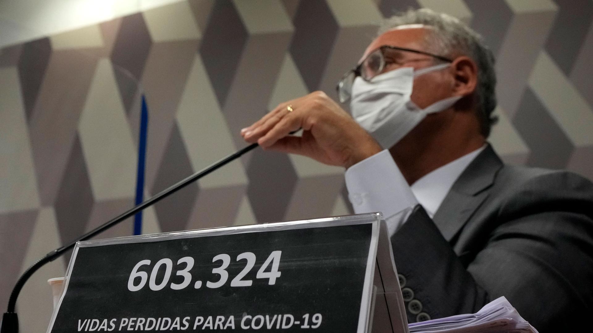 A plaque reads in Portuguese "603,324 lives lost to COVID-19" in front of Senator Renan Calheiros during the session by a Senate committee investigating the handling of the pandemic by the administration of President Jair Bolsonaro.