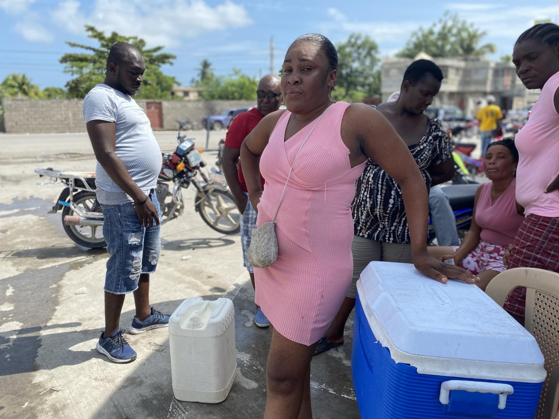 Irlene Devereux, 27, sells shaved ice drenched with cherry and passionfruit syrup to crowds at a gas station in Les Cayes, Haiti, in the country's southern peninsula. An ongoing fuel shortage is worsening as powerful gangs control distribution routes. Dev