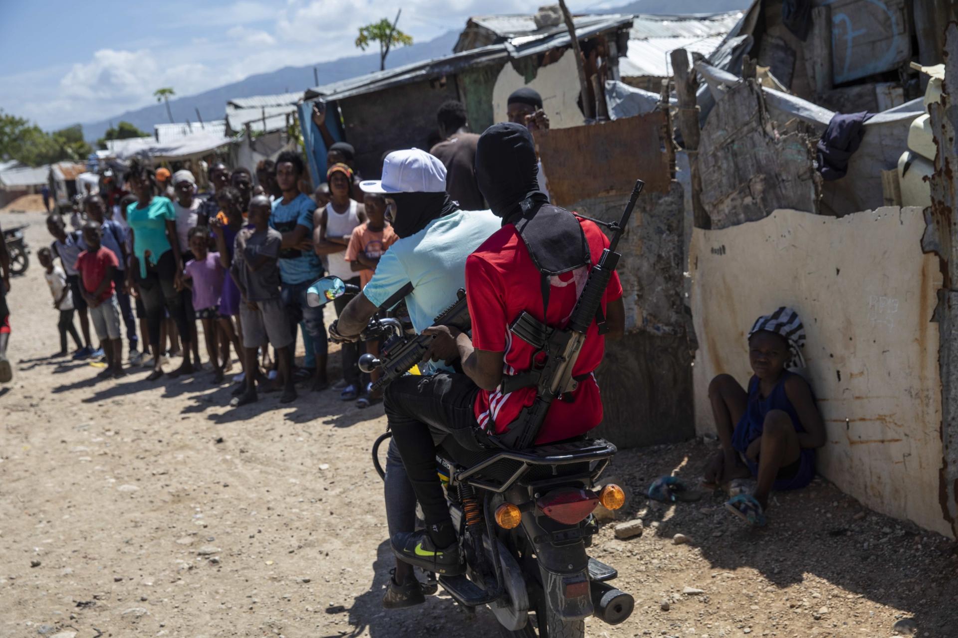 G9 coalition gang members ride a motorcycle through the Wharf Jeremy street market in Port-au-Prince, Haiti, on Oct. 6, 2021. 