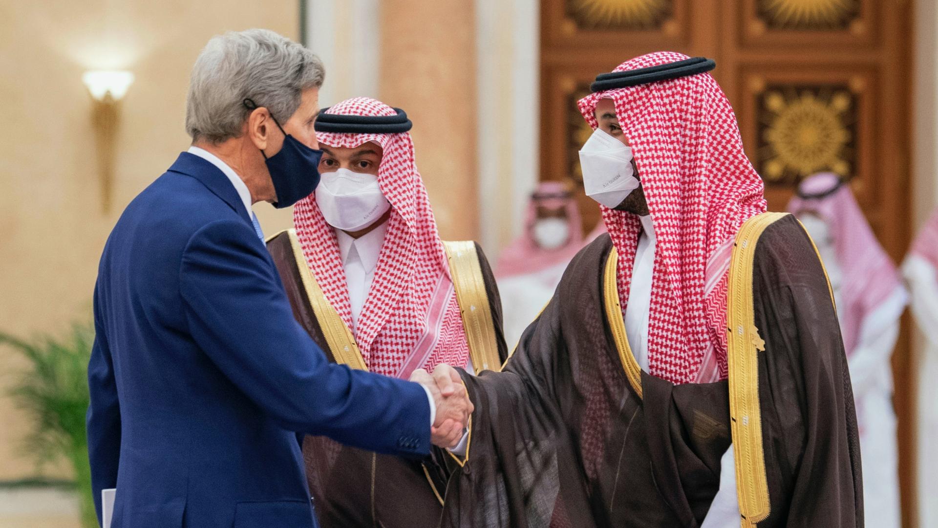 In this photo provided by the Saudi Royal Palace, Saudi Crown Prince Mohammed bin Salman, right, greets US Special Presidential Envoy for Climate John Kerry during the Green Initiative Summit in Riyadh, Saudi Arabia, Oct. 25, 2021.