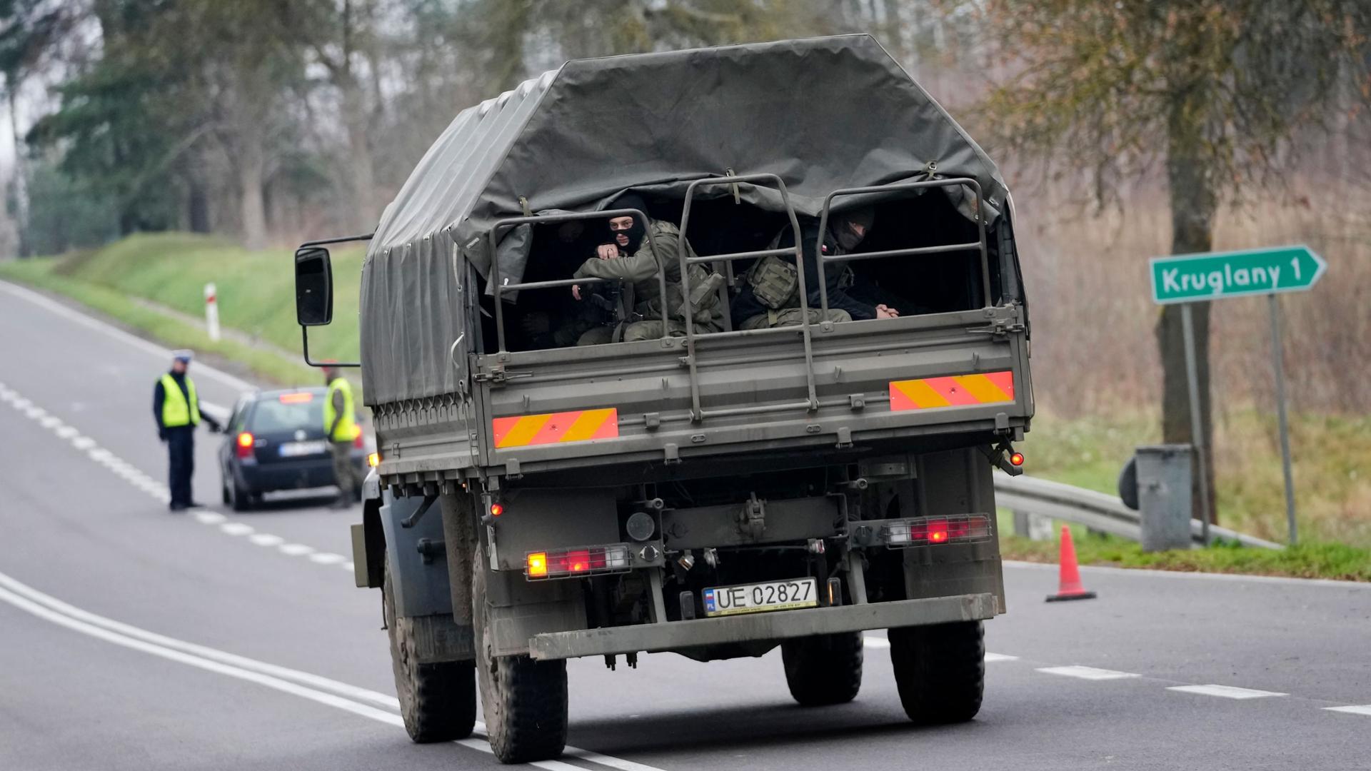 A polish army vehicle drives past a check point close to the border with Belarus in Kuznica, Poland, Tuesday, Nov. 16, 2021.