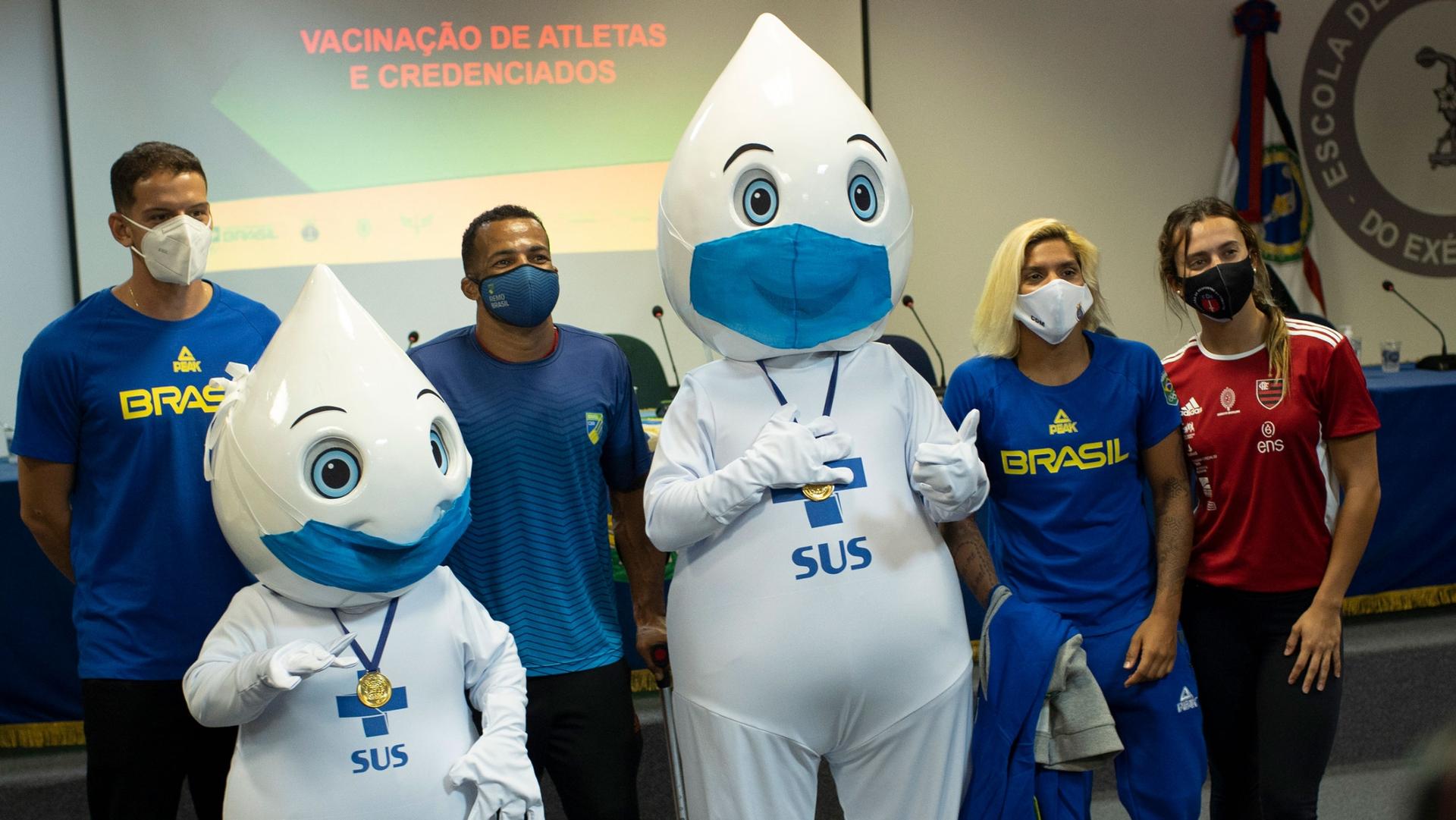 Olympic athletes, from left, archer Marcus Vinicius D'Almeida, Paralympic rower Michel Pessanha, swimmer Marcela Cunha and swimmer Larissa Oliveira pose for a photo with the mascot of the vaccination campaign, named "Zé Gotinha," or "Droplet Joe," after t