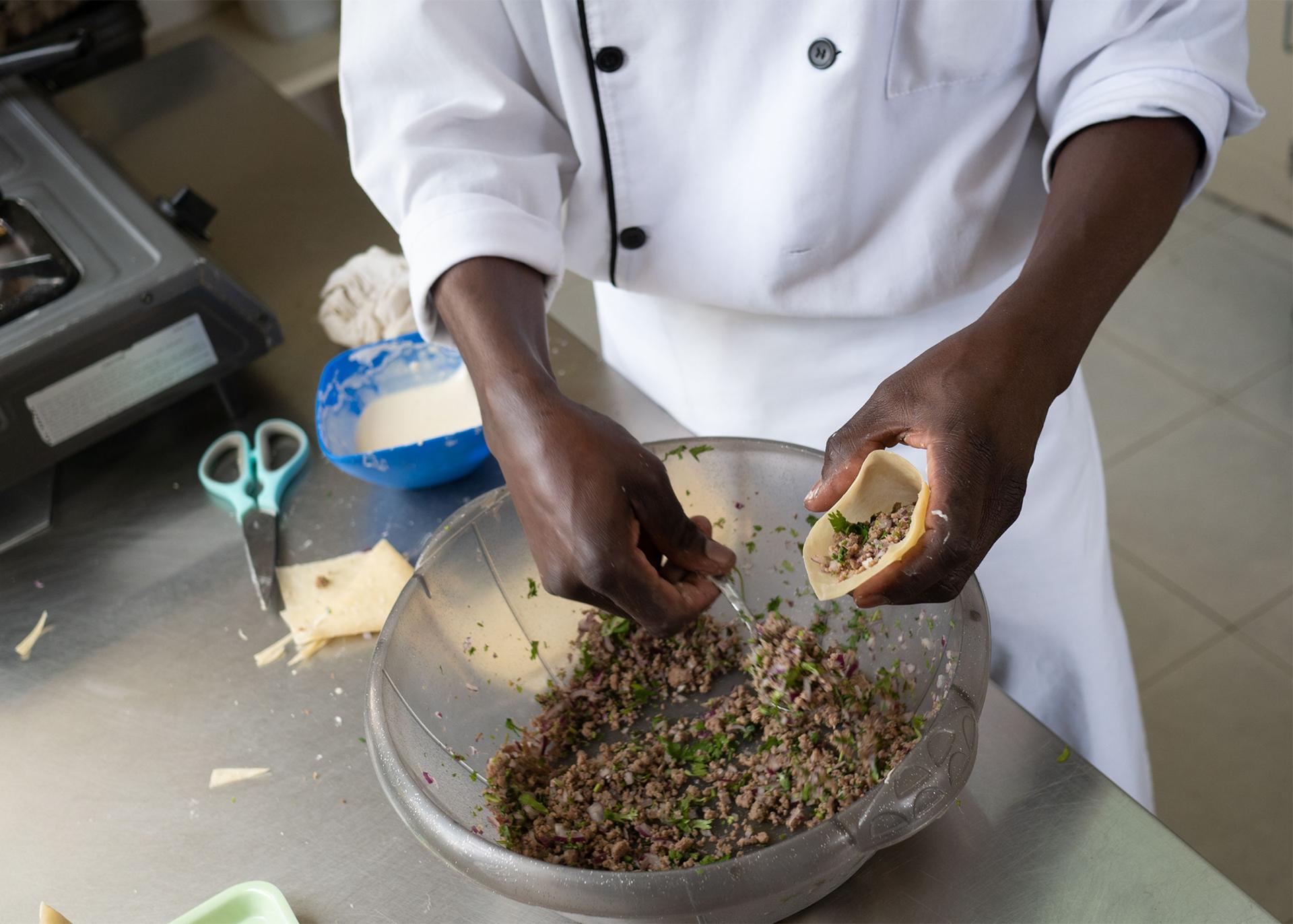 A Wau Eat employee fills mutton samosas, Nairobi, Kenya