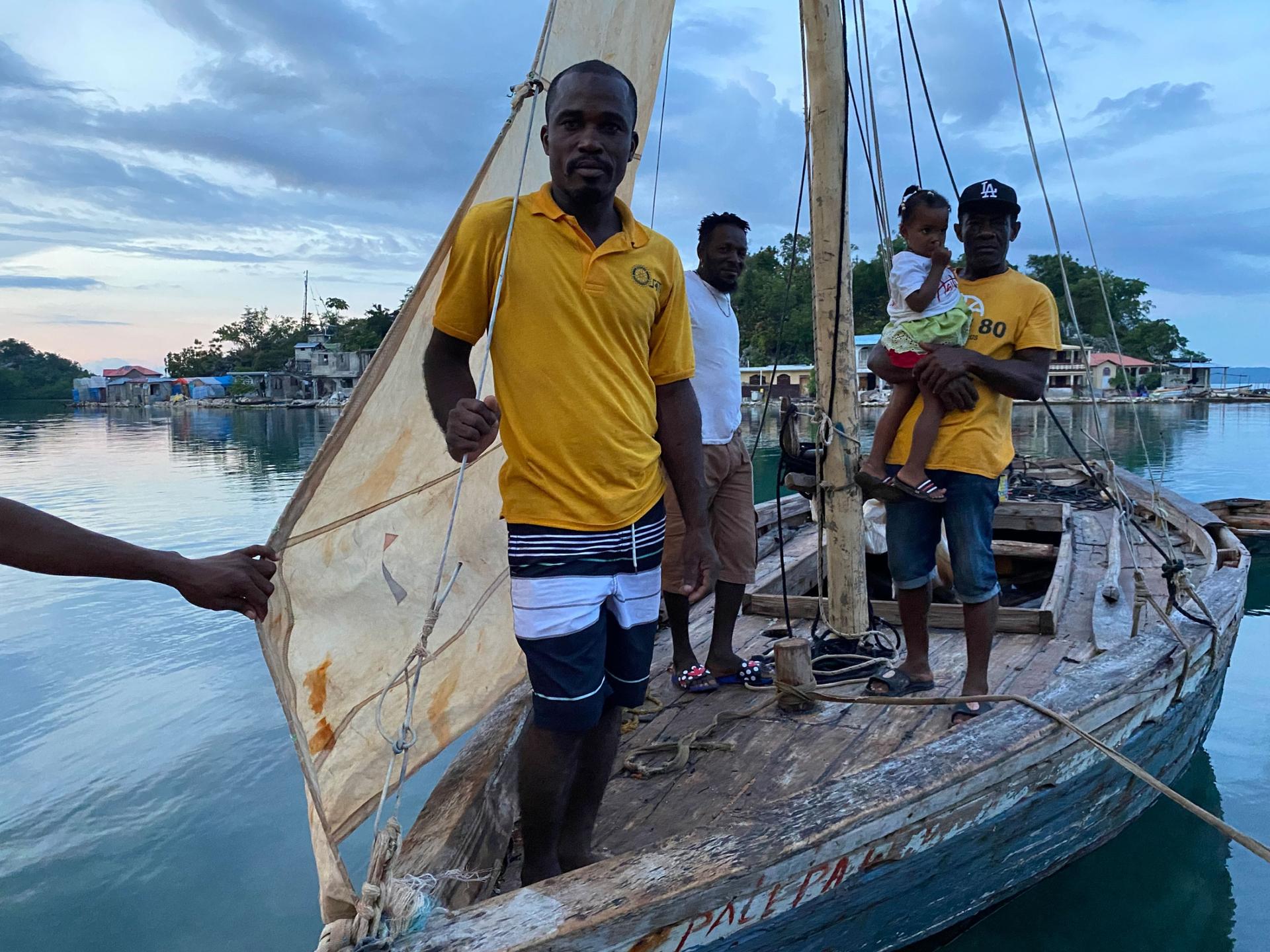 In Pestel, Haiti, on the country's southern peninsula, Jean-Robert Leger, front, stands in a boat that is a bit smaller than the one he has attempted in to sail to the United States, along with many other migrants aboard. 