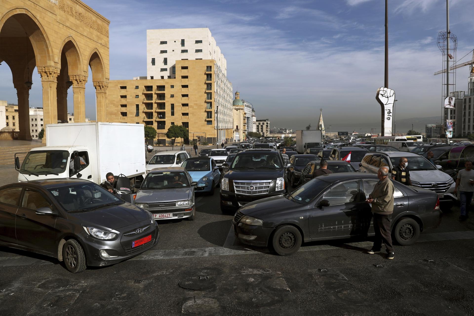 Taxi drivers block a road with their vehicles during a protest against the increasing prices of gasoline, consumer goods and the crash of the local currency, at Martyrs' Square, in downtown Beirut, Nov. 30, 2021.