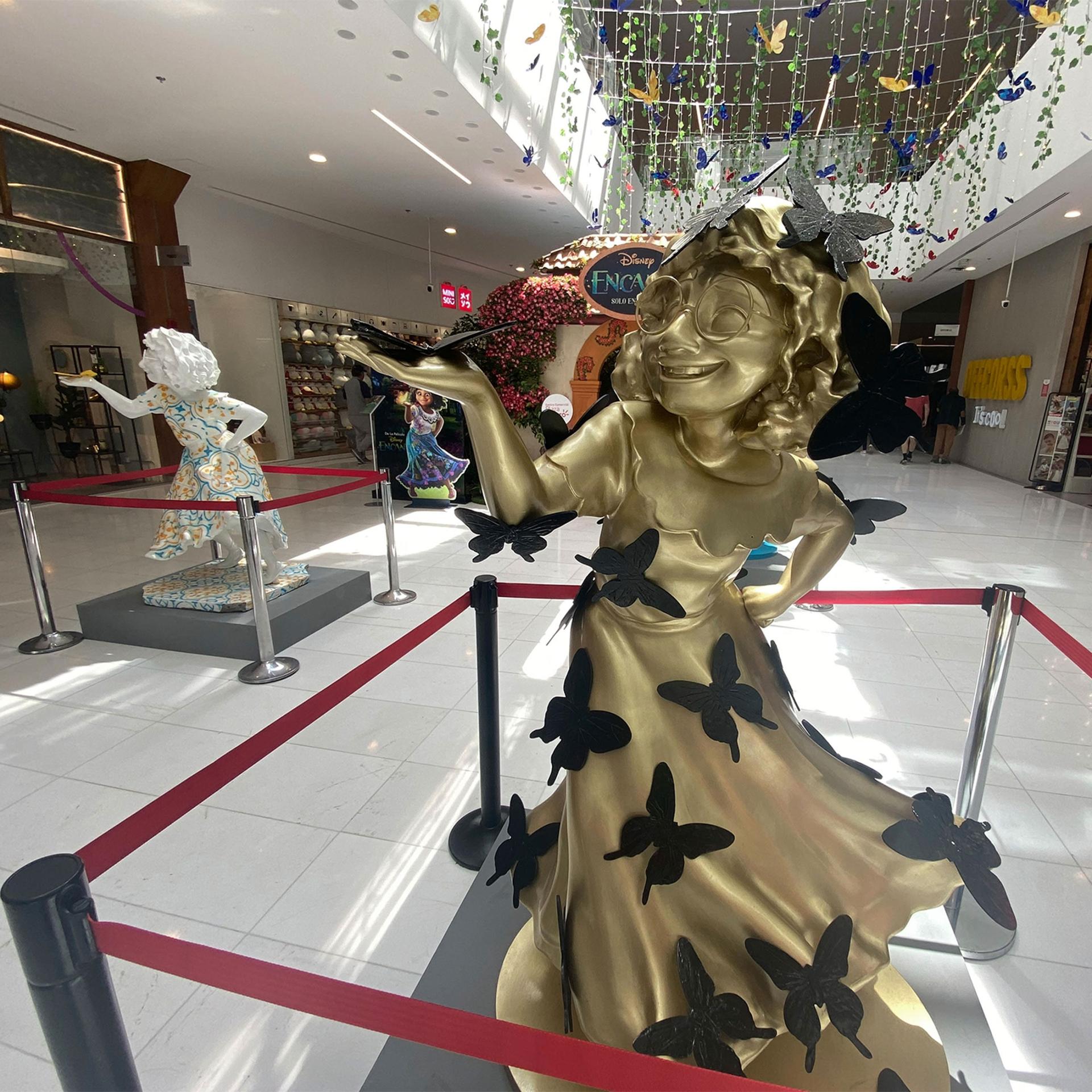 Plaster statues of Mirabel, the main character in “Encanto," stand at the entrance to a shopping mall in Bogotá, Colombia.