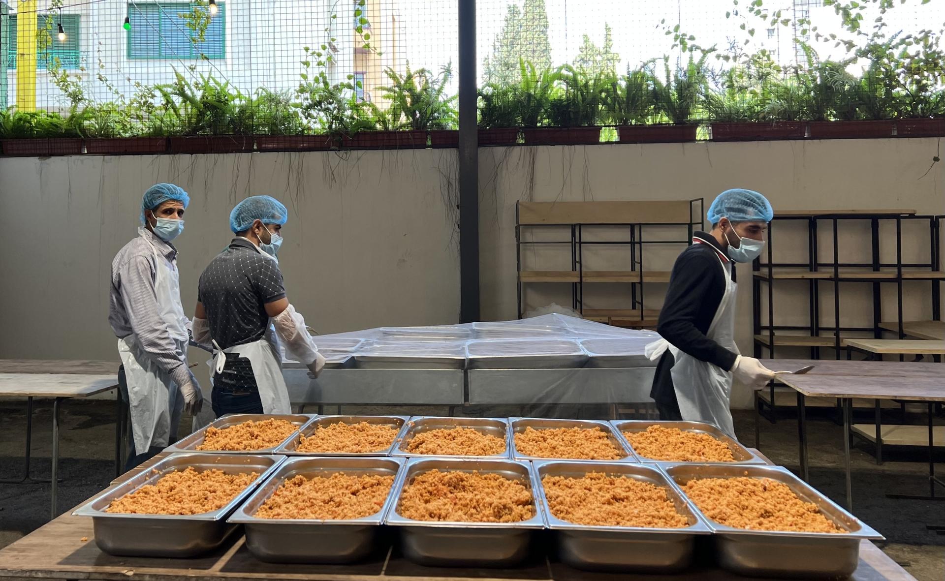 Workers at the Matbakh El Kell Community Kitchen in Beirut prepare food for distribution.