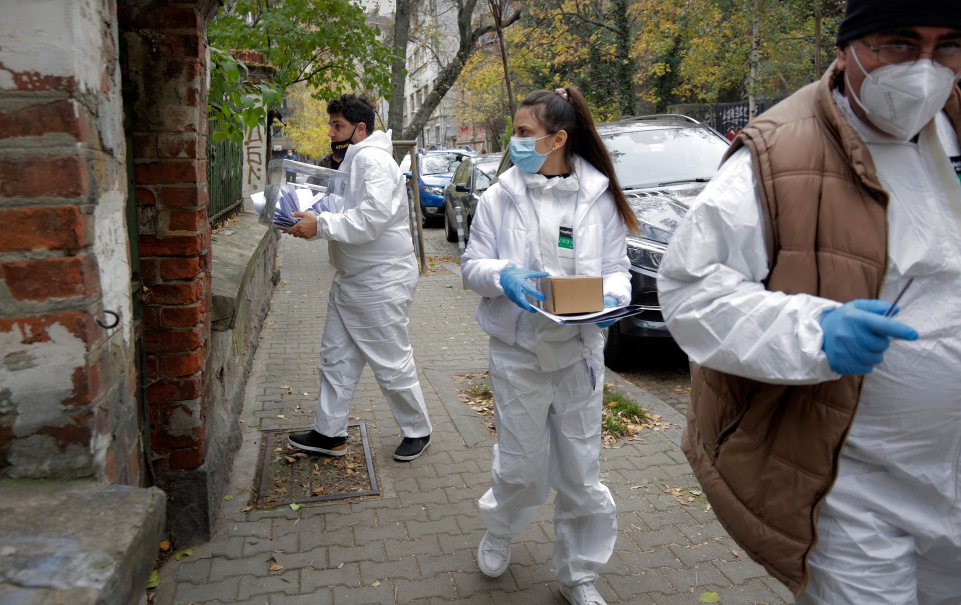 Election officers dressed in protective gear to protect from COVID-19 go to the addresses of sick people to allow them to cast their votes, in Sofia, Sunday, Nov. 14, 2021. 