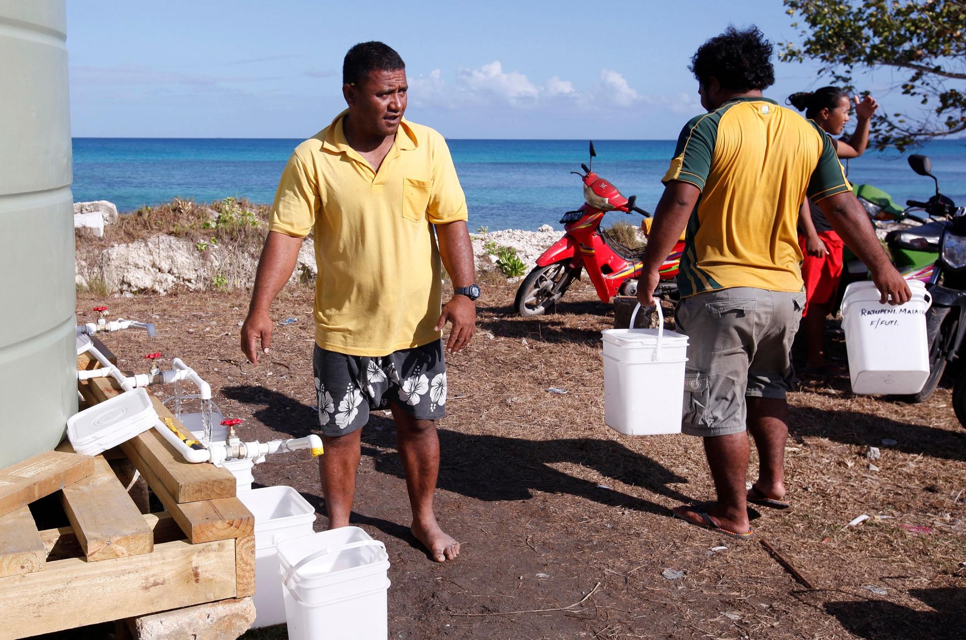 In this Oct. 13, 2011, file photo, residents collect their morning ration of fresh water made from desalinated sea water in Funafuti, Tuvalu while the atolls are suffering a severe drought and water shortage. 