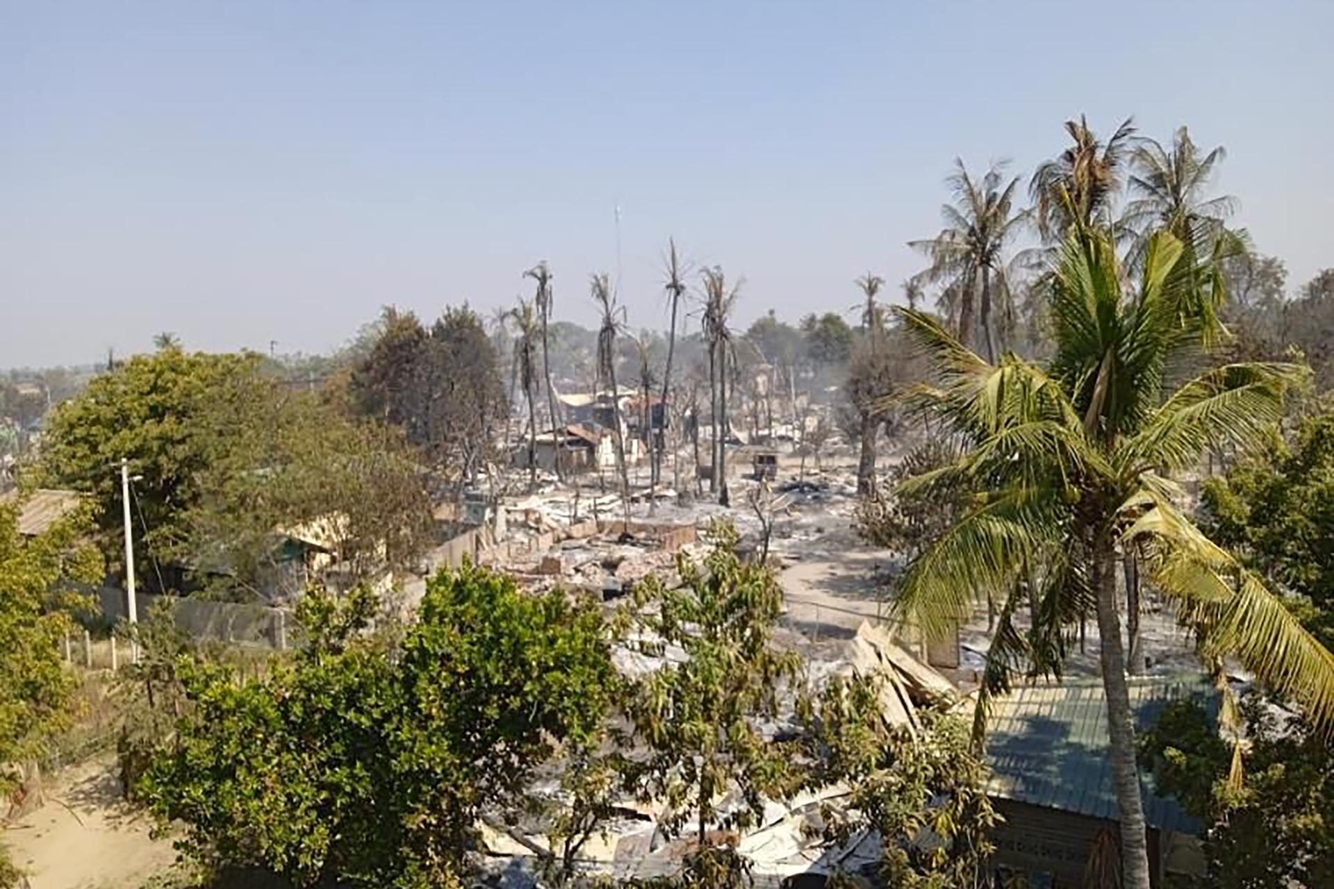 Charred houses sit in ash between the trees in Mwe Tone village of Pale township in the Sagaing region, Myanmar on Feb. 1, 2022. Mwe Tone was one of two villages residents and Myanmar news outlets said were burned down Monday, Jan. 31, 2022, by soldiers t