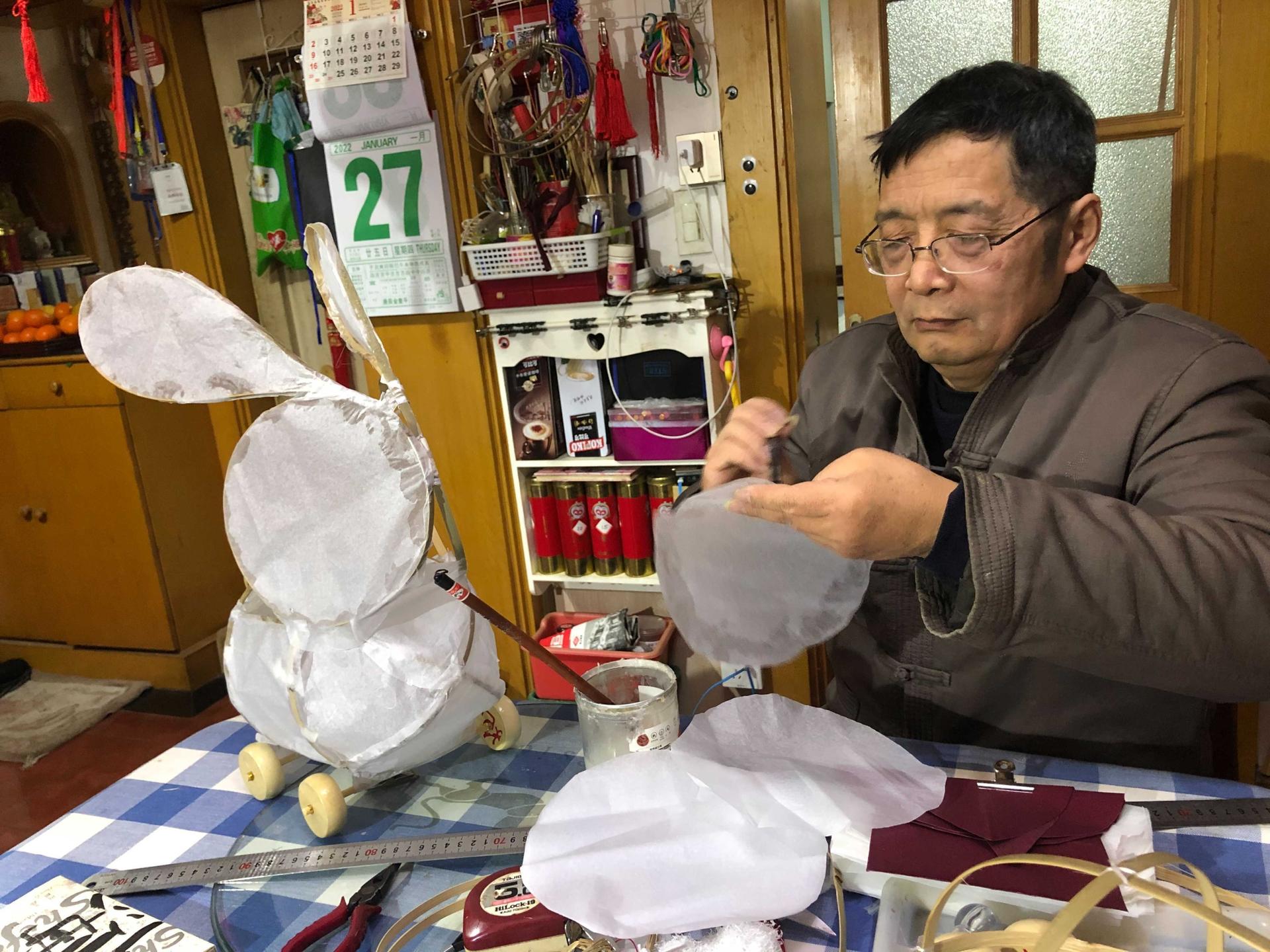 Li Jianguo making a rabbit lantern in his home workshop.