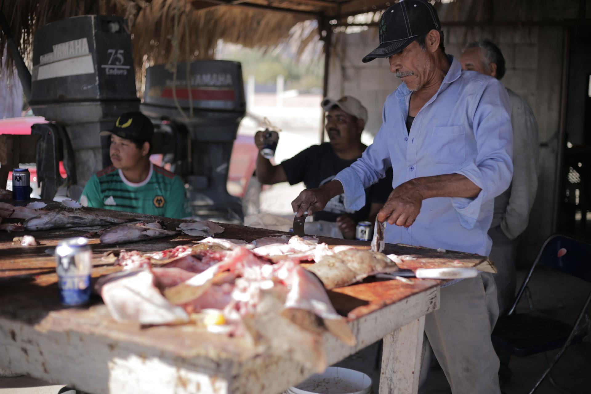 Fisherman Jose Antonio Cruz Espinoza cuts fish in the market. 