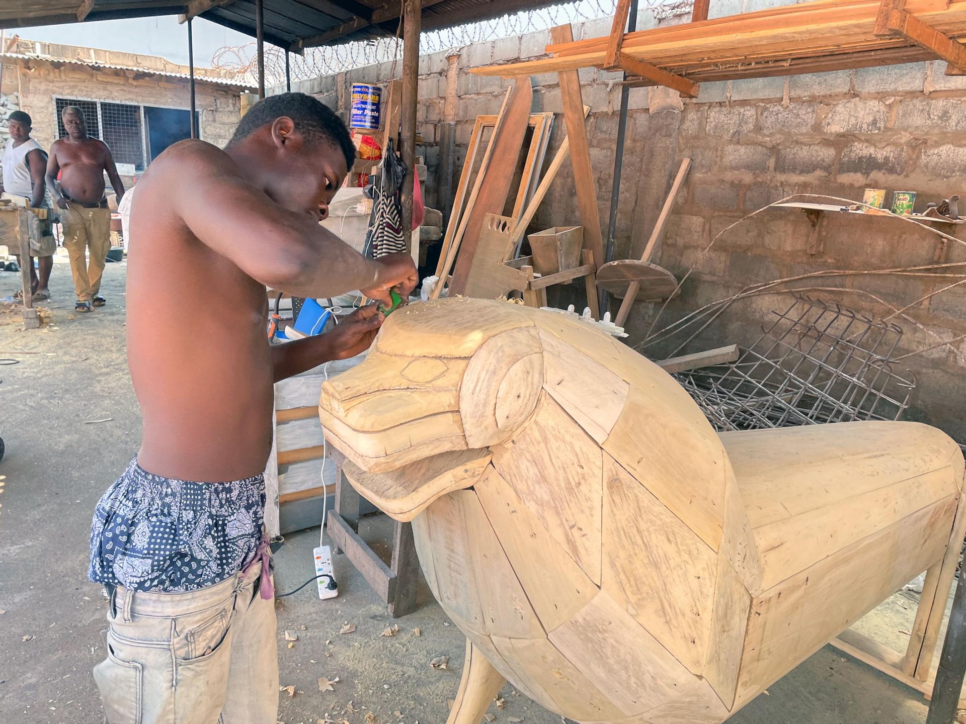 Lawrence Anang works on the lion-shaped coffin. 