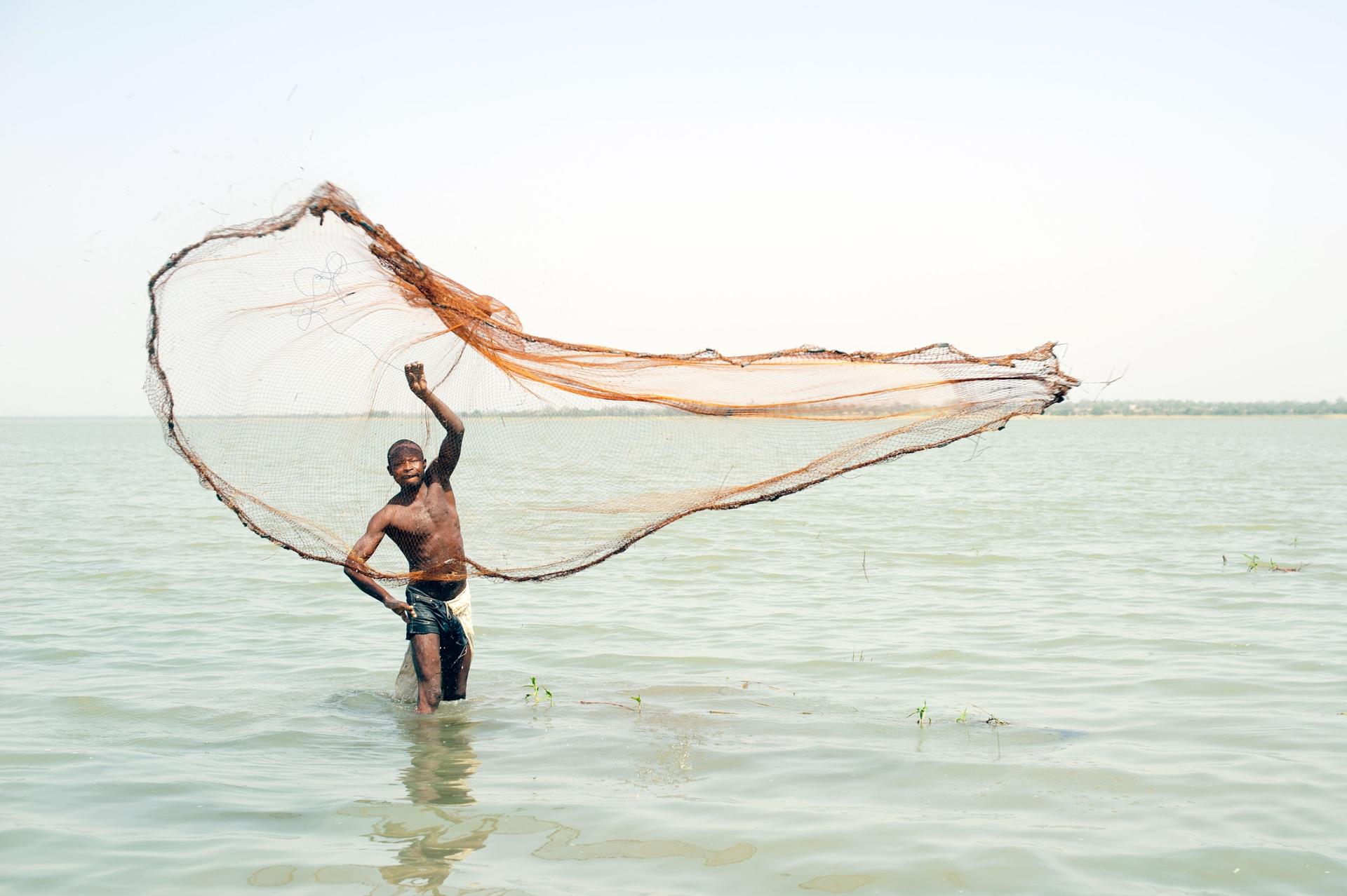 A fisherman casts his net in Ghana. 