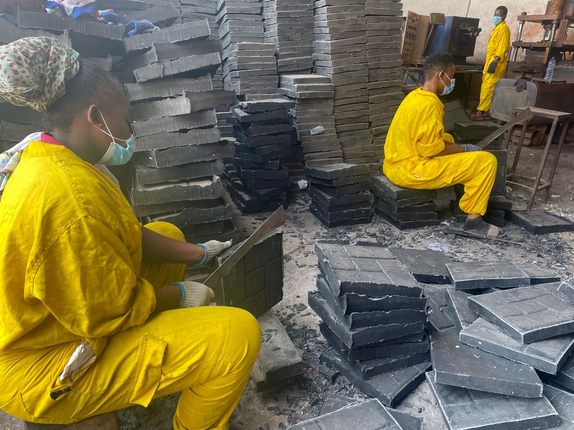 Workers shape molded blocks at Nelplast in Ghana. 