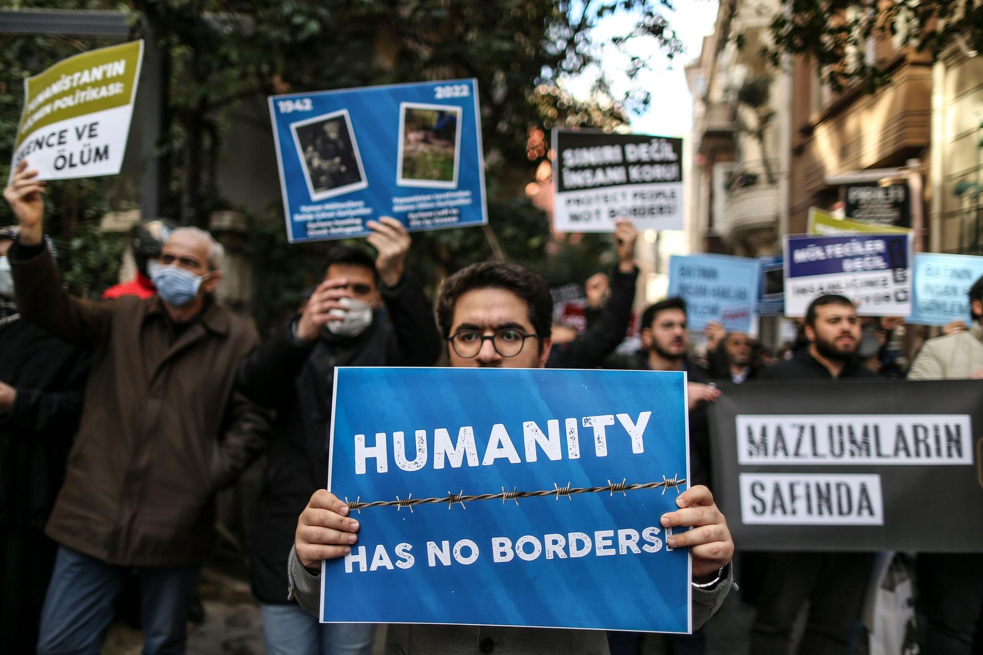 Members of human rights and migrant rights groups hold placards in Turkish and English as they gather in front of the Greek consulate in Istanbul, Saturday, Feb. 5, 2022, to protest the deaths of migrants at Turkey-Greece border. 