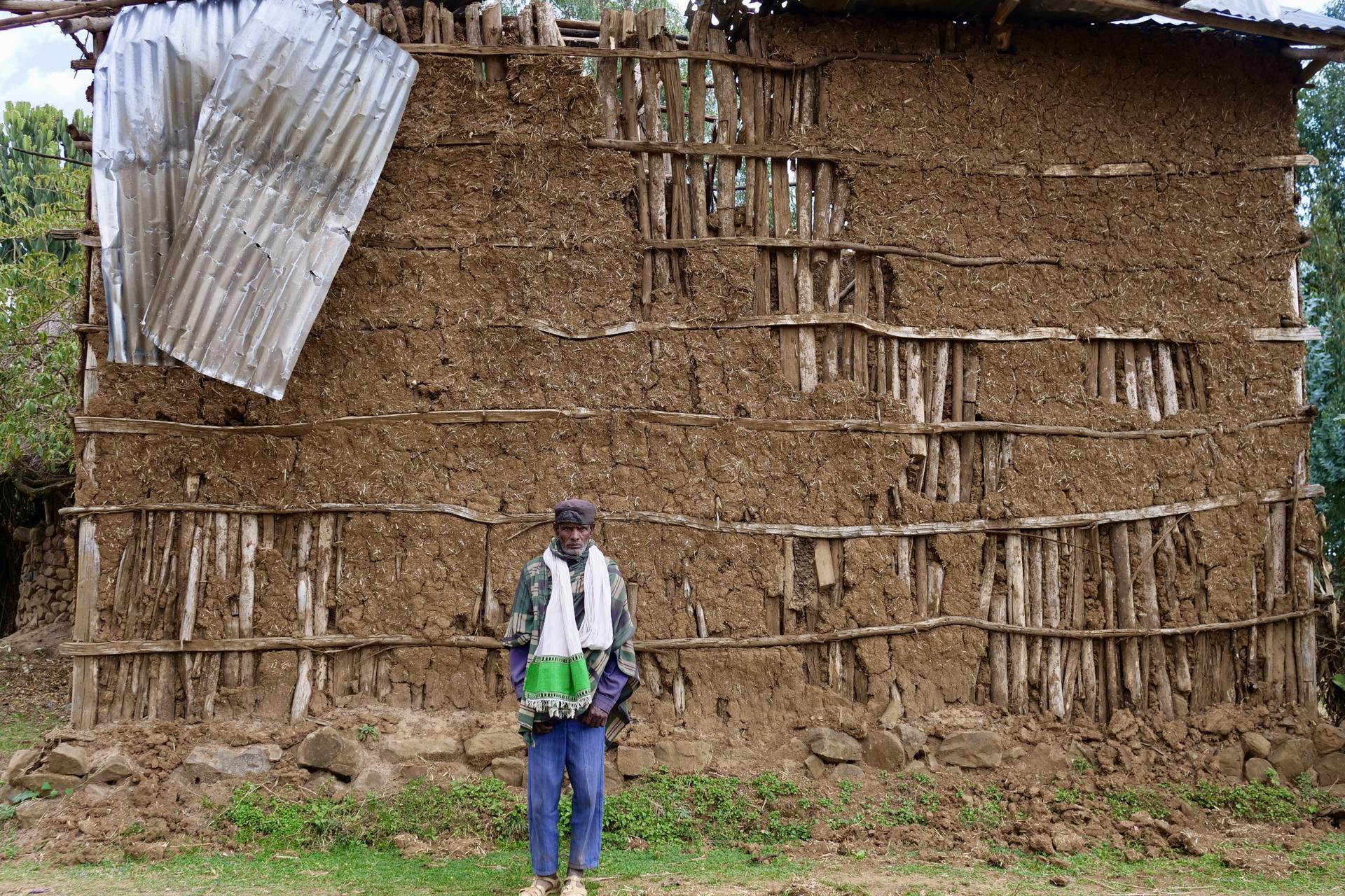 Farmer Gashaw Demise stands in front of his home, which was partially damaged during the conflict. His family was killed when the house was struck by a weapon, Amhara, Ethiopia, Feb. 17, 2022.