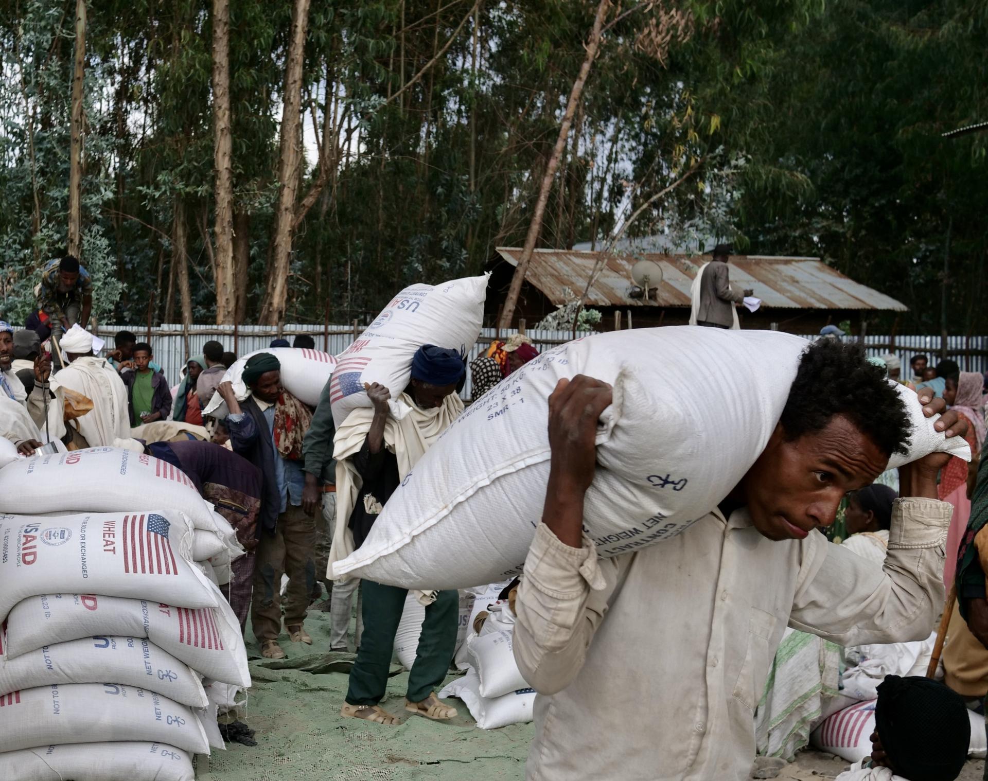 People collect food aid at a distribution warehouse in Meket District, Amhara Region, Ethiopia, Feb. 17, 2022.