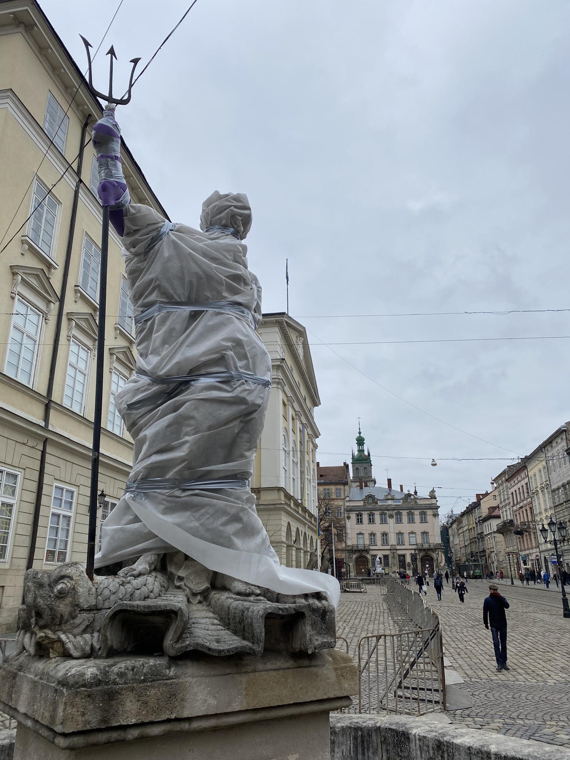The statue of Roman god Neptune wrapped in plastic and foam in Lviv's medieval Market Square 