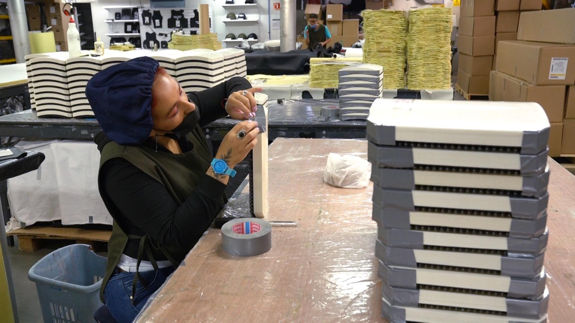 A woman at the MC Armor plant in Bogota, Colombia, works with ceramic plates — which have become more expensive — that will go inside bulletproof vests.