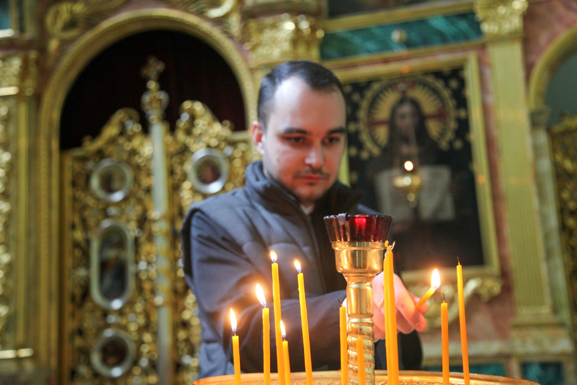 Father Dmytro Fedlyuk lights candles before a christening at the Ukrainian Catholic church in Krakow, Poland.