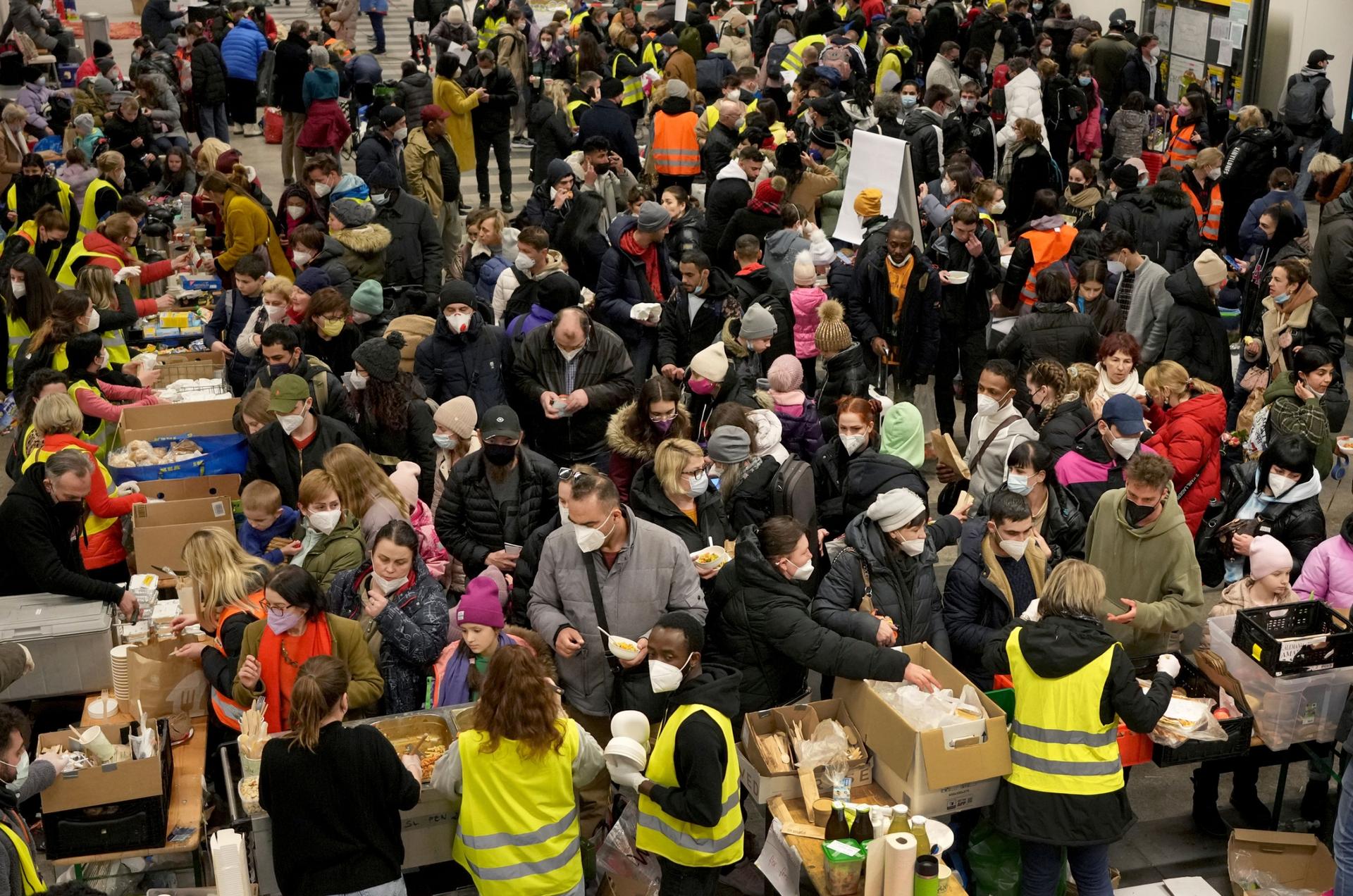 Ukrainian refugees queue for food in the welcome area after their arrival at the main train station in Berlin, Germany, Tuesday, March 8, 2022.