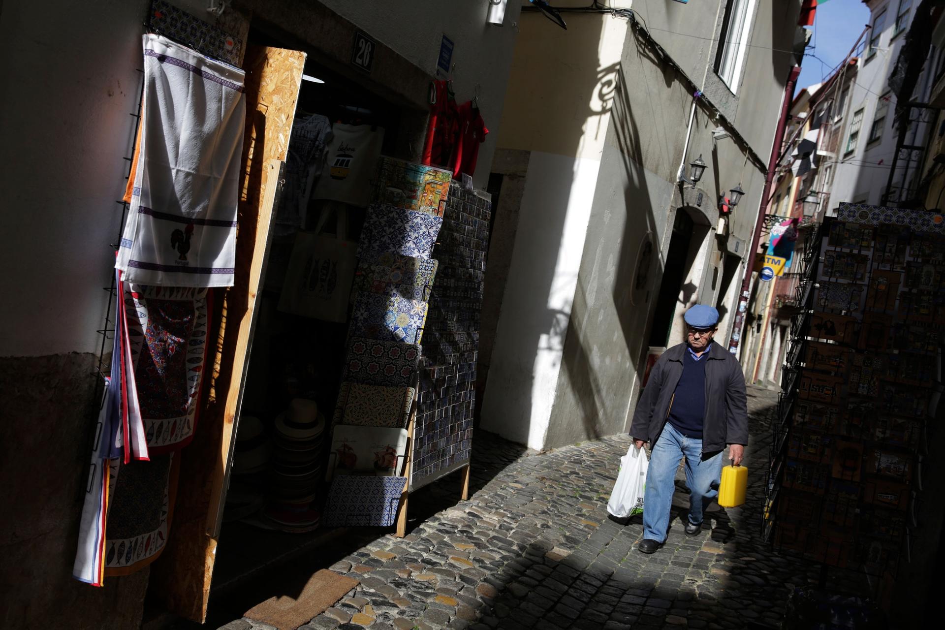 A man walks in Lisbon's old Alfama riverside neighborhood Friday, March 13, 2020.