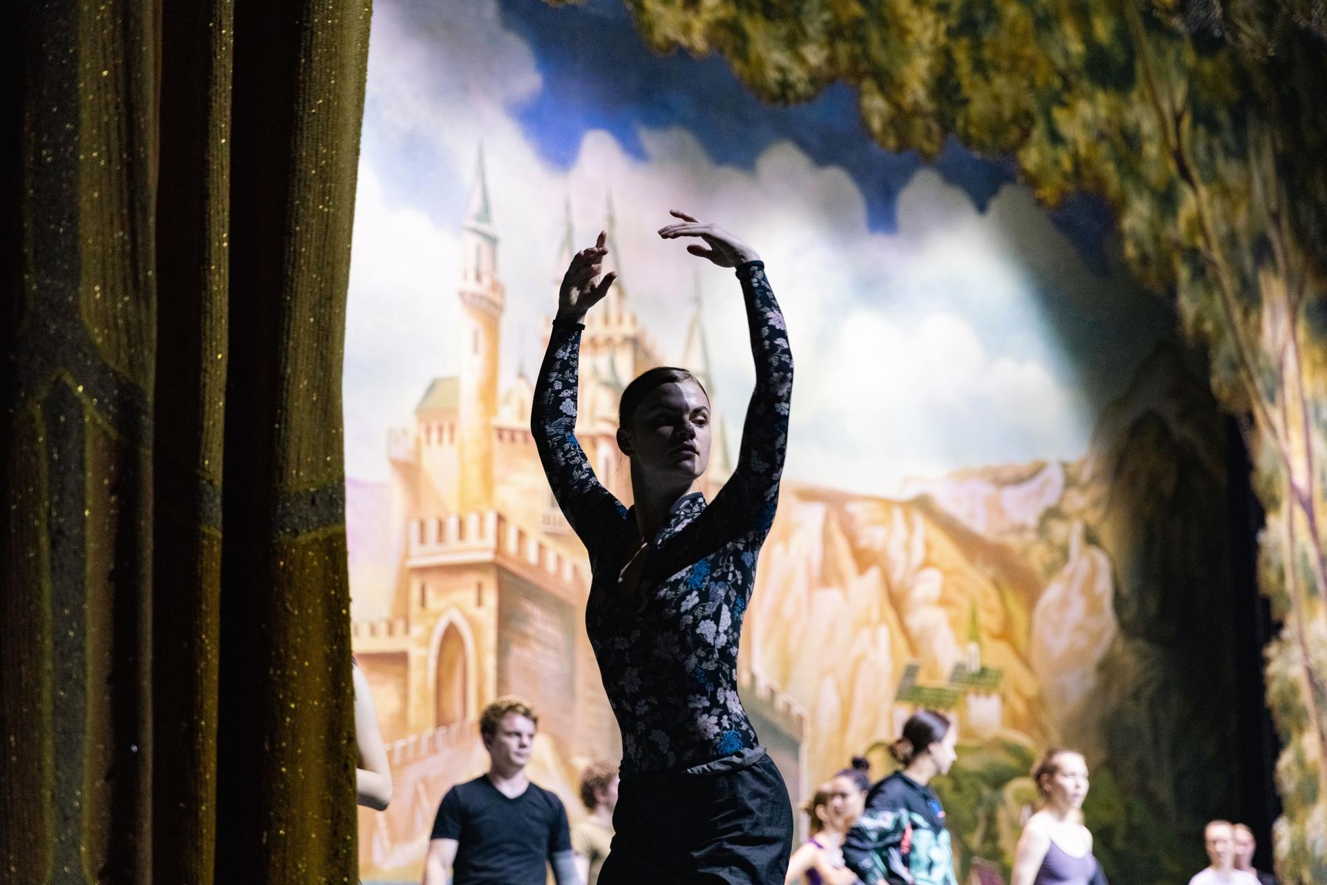 dancers rehearse onstage with a backdrop
