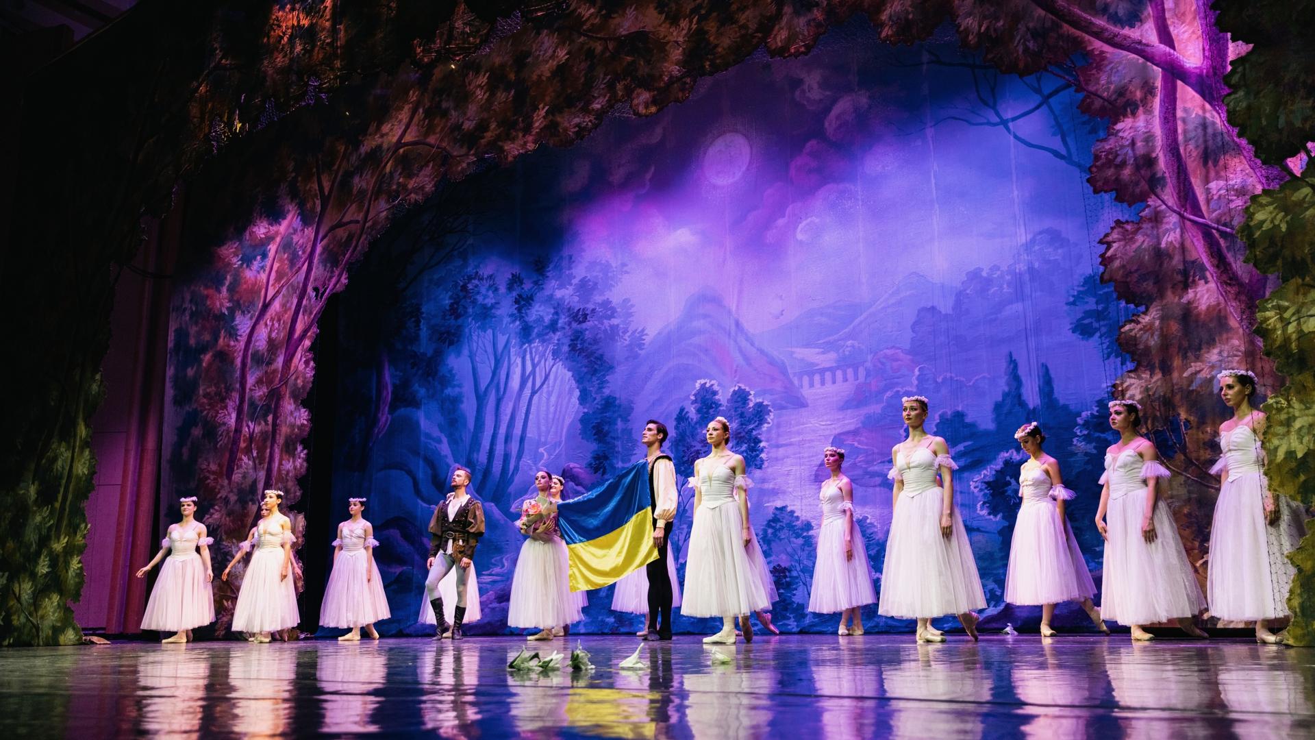 The Ukrainian Classical Ballet company holds up the Ukrainian flag onstage during curtain call while the Ukrainian national anthem plays as part of a performance in Bucharest, Ukraine.