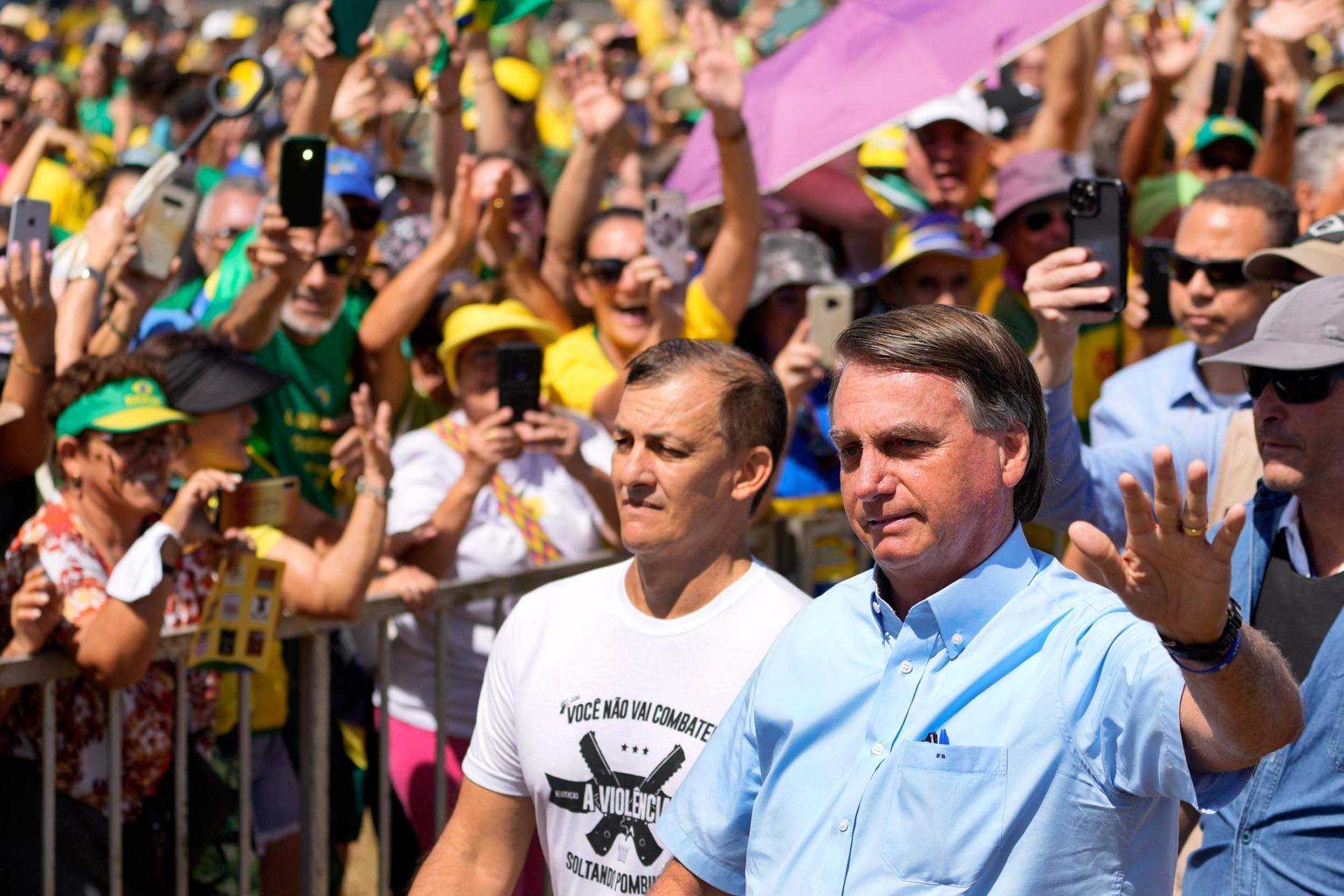 Brazil's President Jair Bolsonaro waves to supporters as he arrives at the Labor Day and Freedom rally, in Brasilia, Brazil, Sunday, May 1, 2022. 