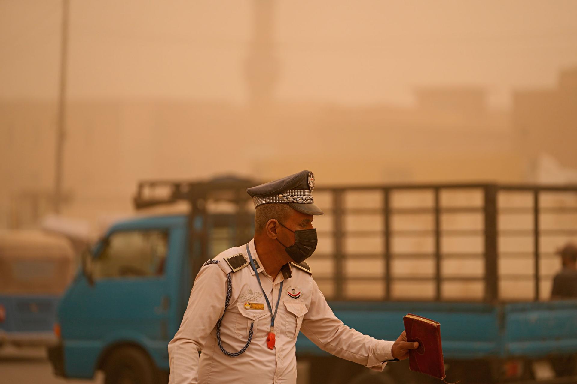 A policeman stands during a sandstorm in Baghdad, Iraq, Monday, May 23, 2022.