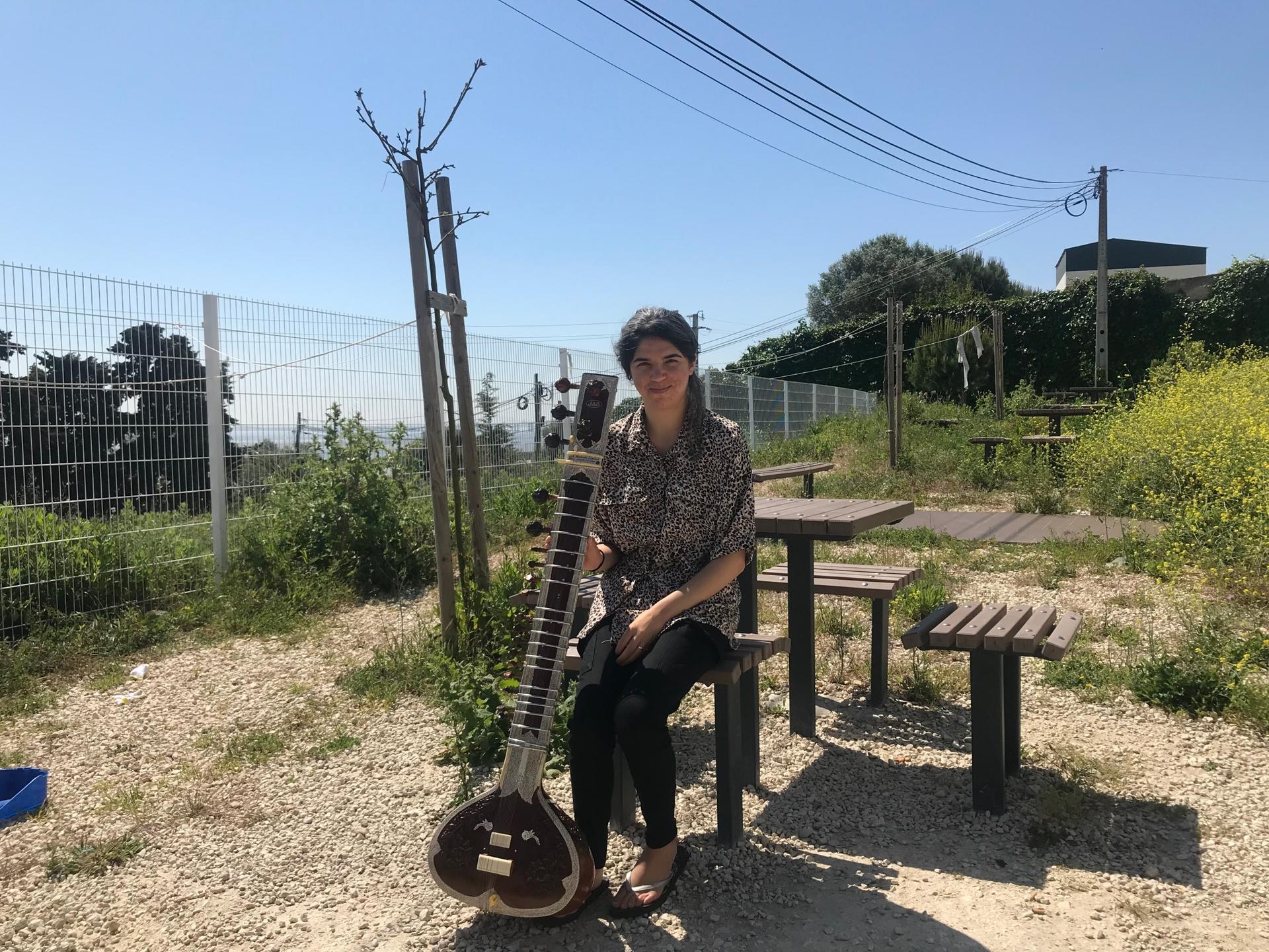 Huma Rahimi with her new sitar on the terrace at the refugee center outside Lisbon where she is staying. 
