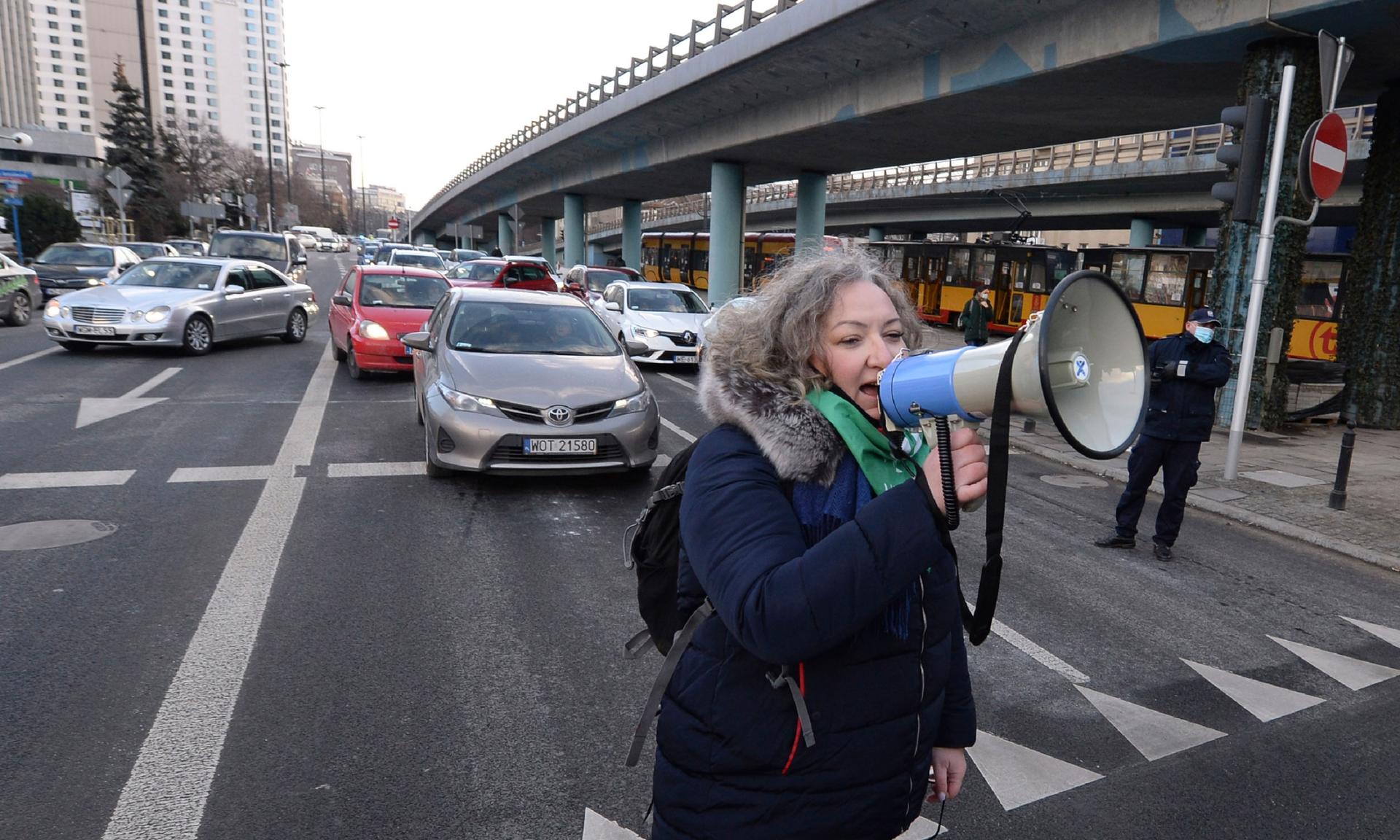 Marta Lempart, a leader of Polish Women's Strike, uses a megaphone to address protesters who gathered for a protest, on International Women's Day in Warsaw, Poland, Monday March 8, 2021. 